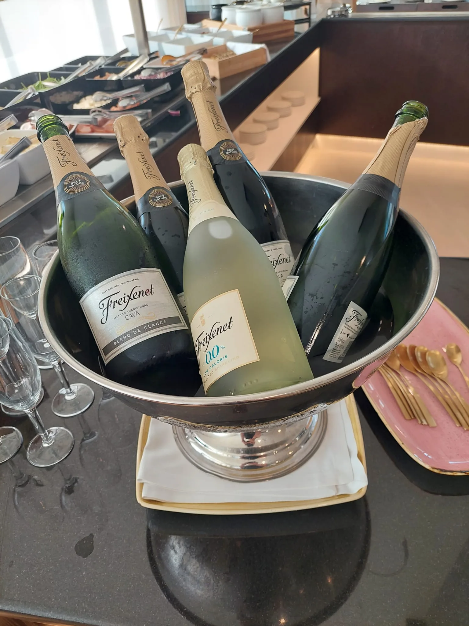Eisgekühlte Flaschen Freixenet im Eiskübel auf dem Frühstückstisch