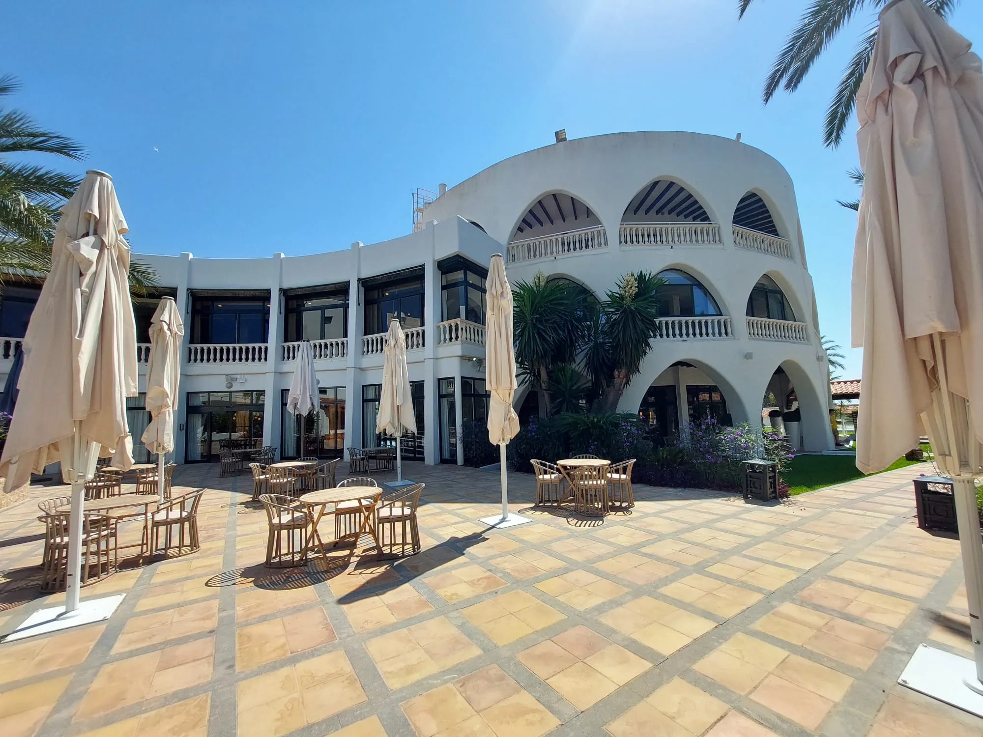 Außenbereich eines Hotels mit Sonnenschirmen und Tischen