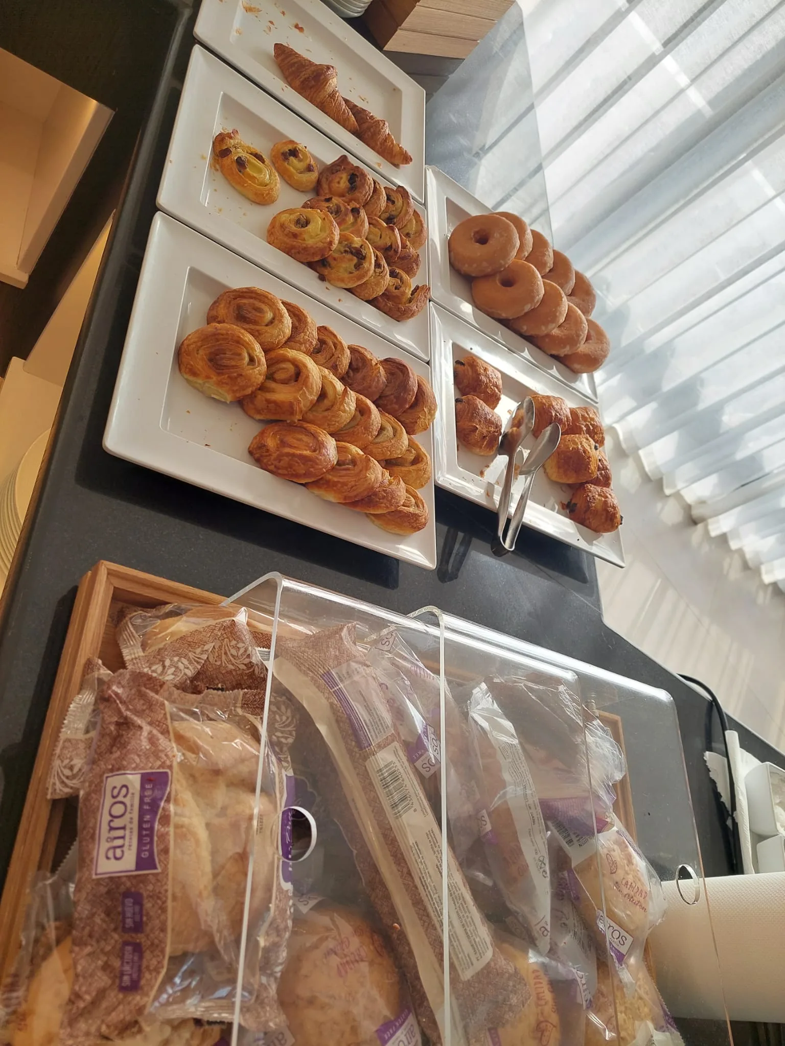 Frühstückstisch mit Keksen, Donuts und Brot