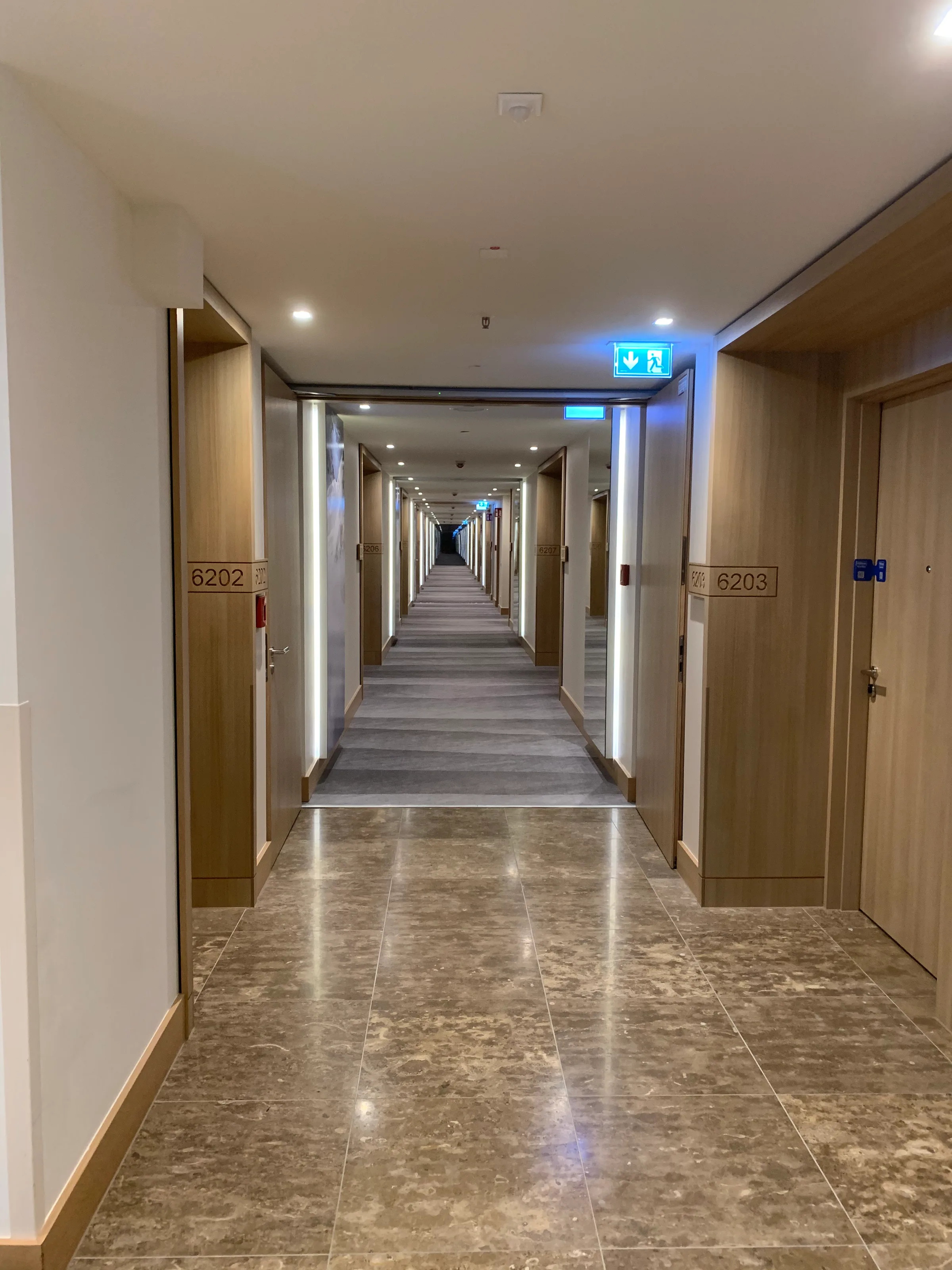 Hotelkorridor mit Zimmertüren und Nummernschildern