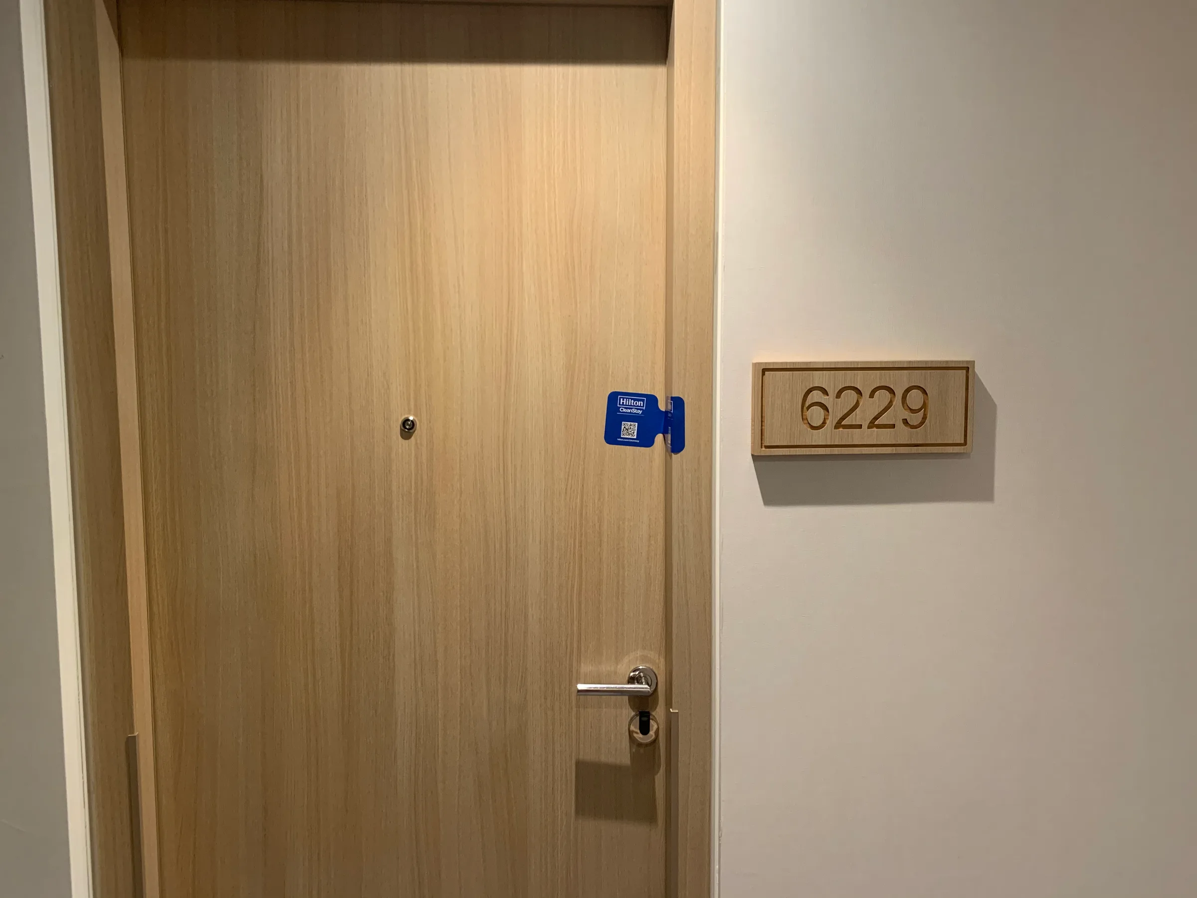 Holztür mit Zimmernummer 6229 und blauer Schlüsselanhänger