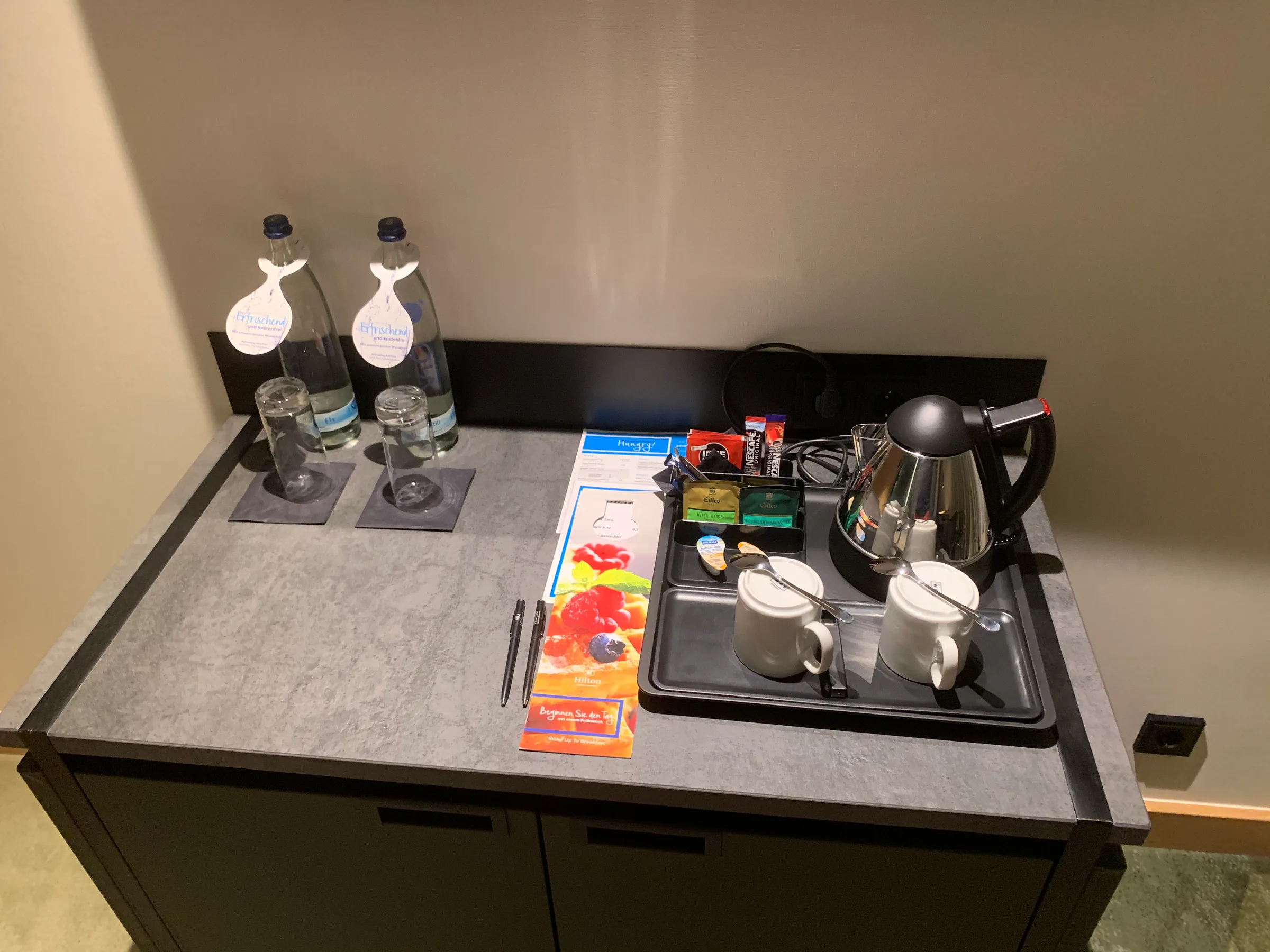 Hotelzimmertisch mit Tee-Set und Mineralwasserflaschen