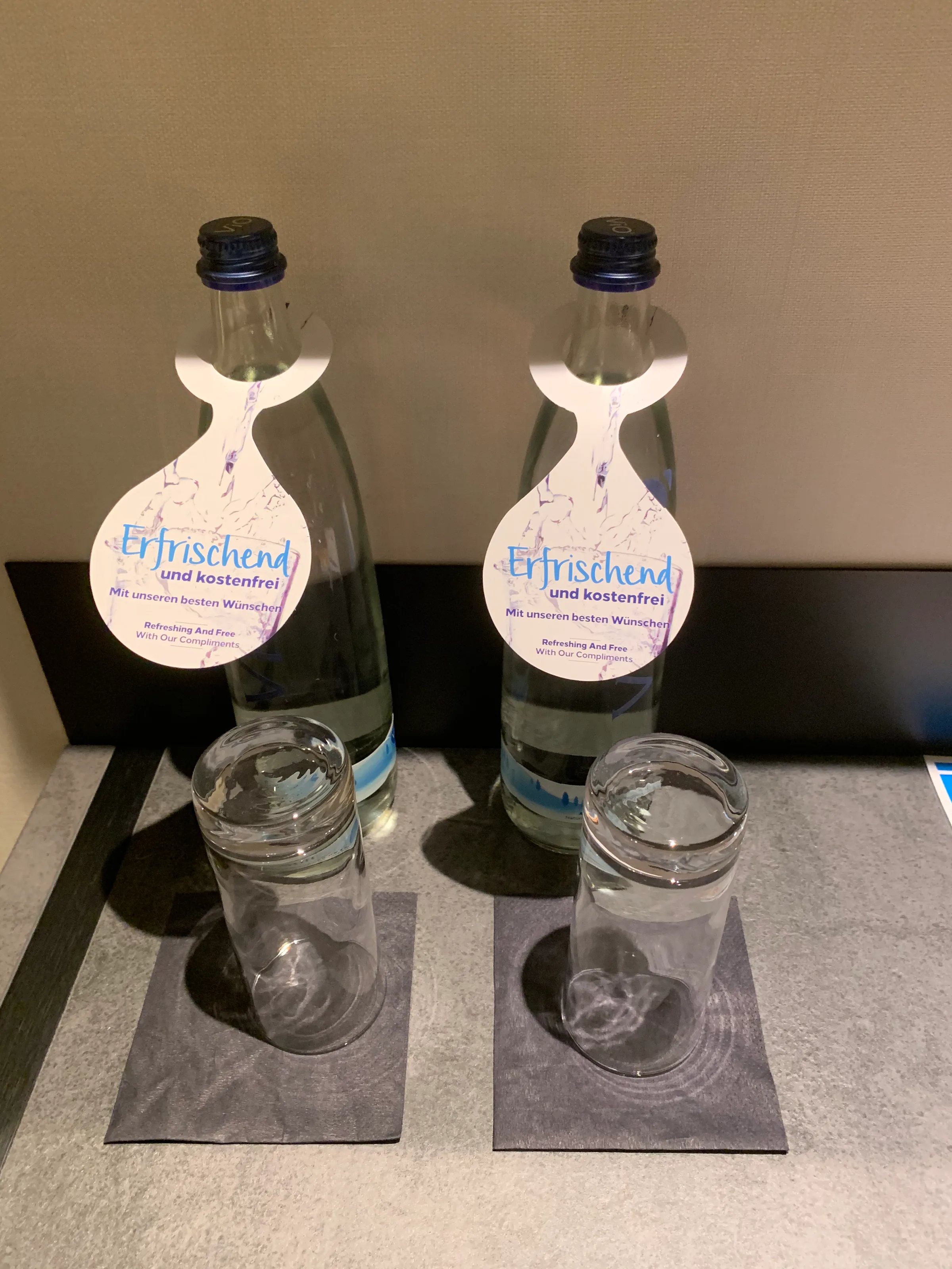 Zwei Flaschen Wasser mit Etiketten auf Tisch