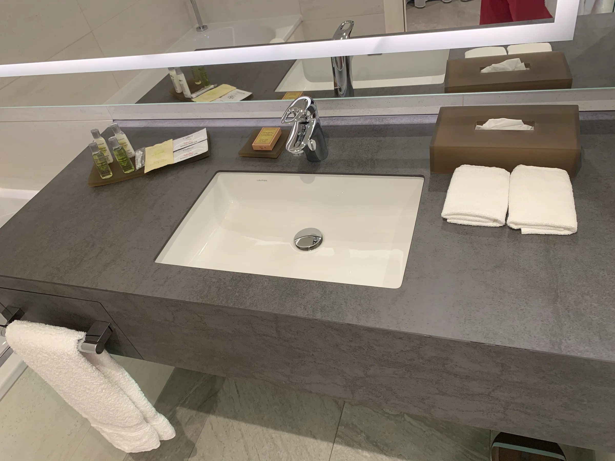 Hotelwaschtisch mit Waschbecken, Handtüchern und Kosmetikset