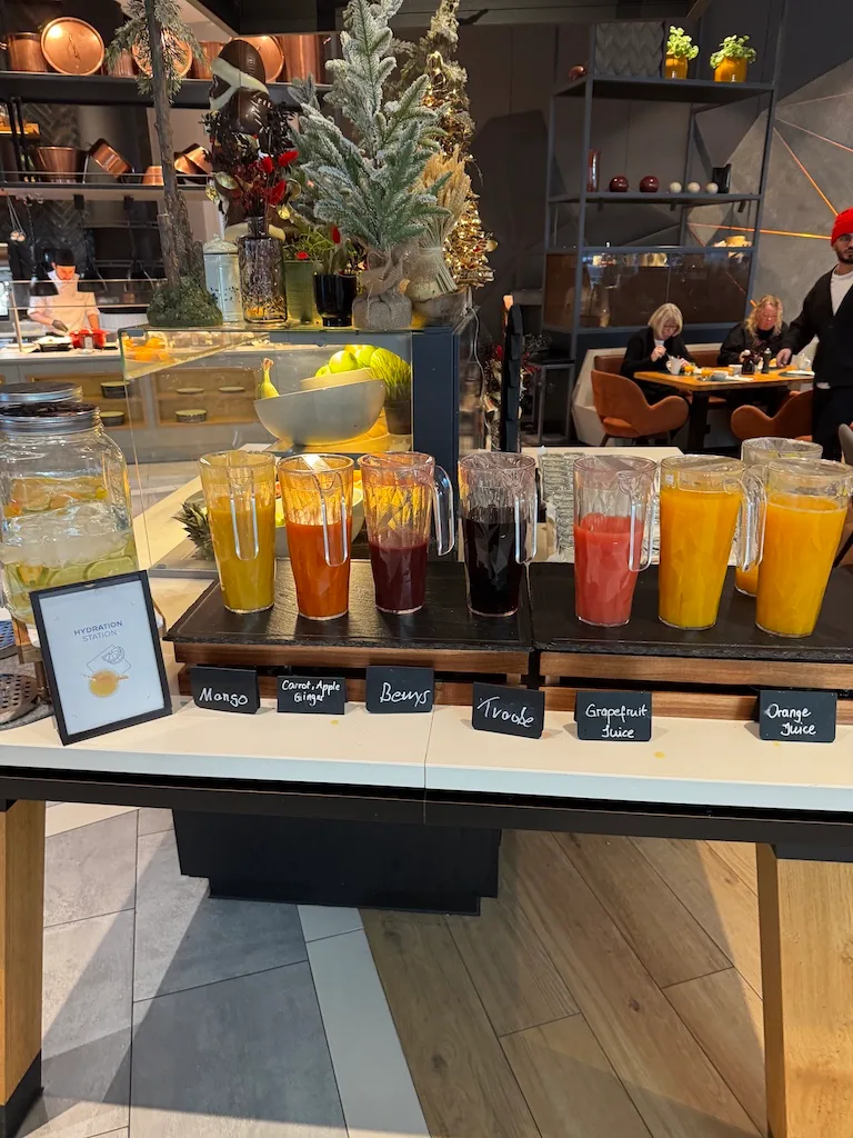 Fruchtsäfte auf Schanktisch im Hotel mit Weihnachtsdeko im Hintergrund