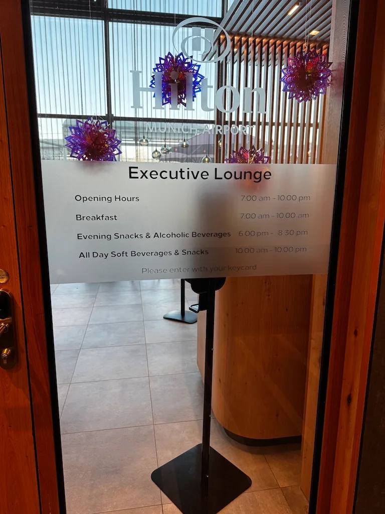 Tür zum Executive Lounge mit Öffnungszeiten und Speisenangebot