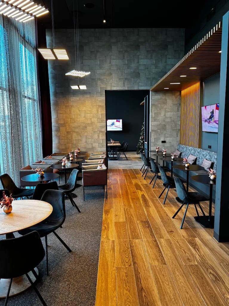 Hotellobby mit Holzboden und grauen Sitzmöbeln