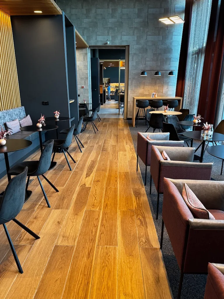 Lounge mit Holzboden und Sitzmöbeln in Grau und Braun