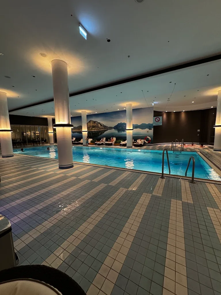Indoor Pool mit Säulen und Landschaftsbild an der Wand