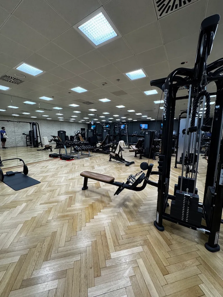 Fitnessraum mit Holzboden und verschiedenen Trainingsgeräten