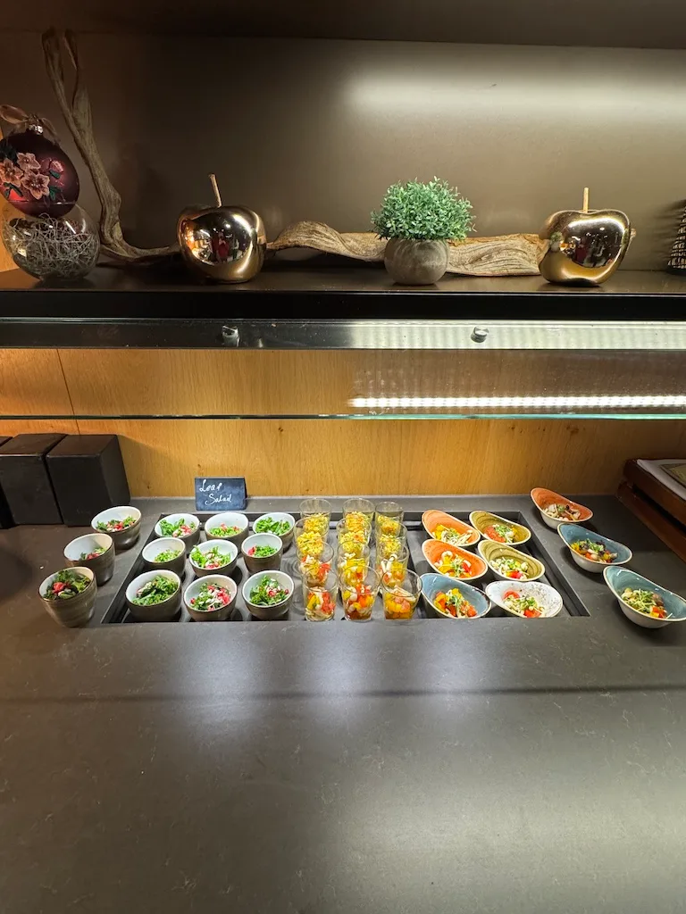 Salatbuffet mit verschiedenen Salaten in Schalen und Gläsern