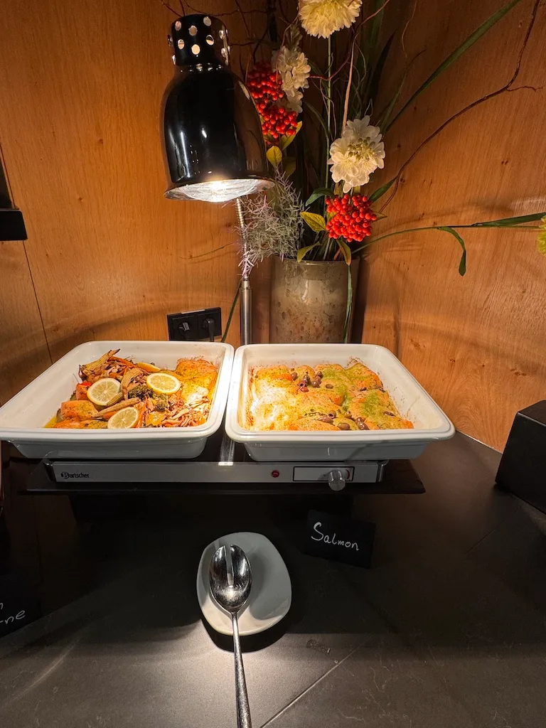 Buffet mit Lachs und anderen Gerichten auf Wärmeplatten