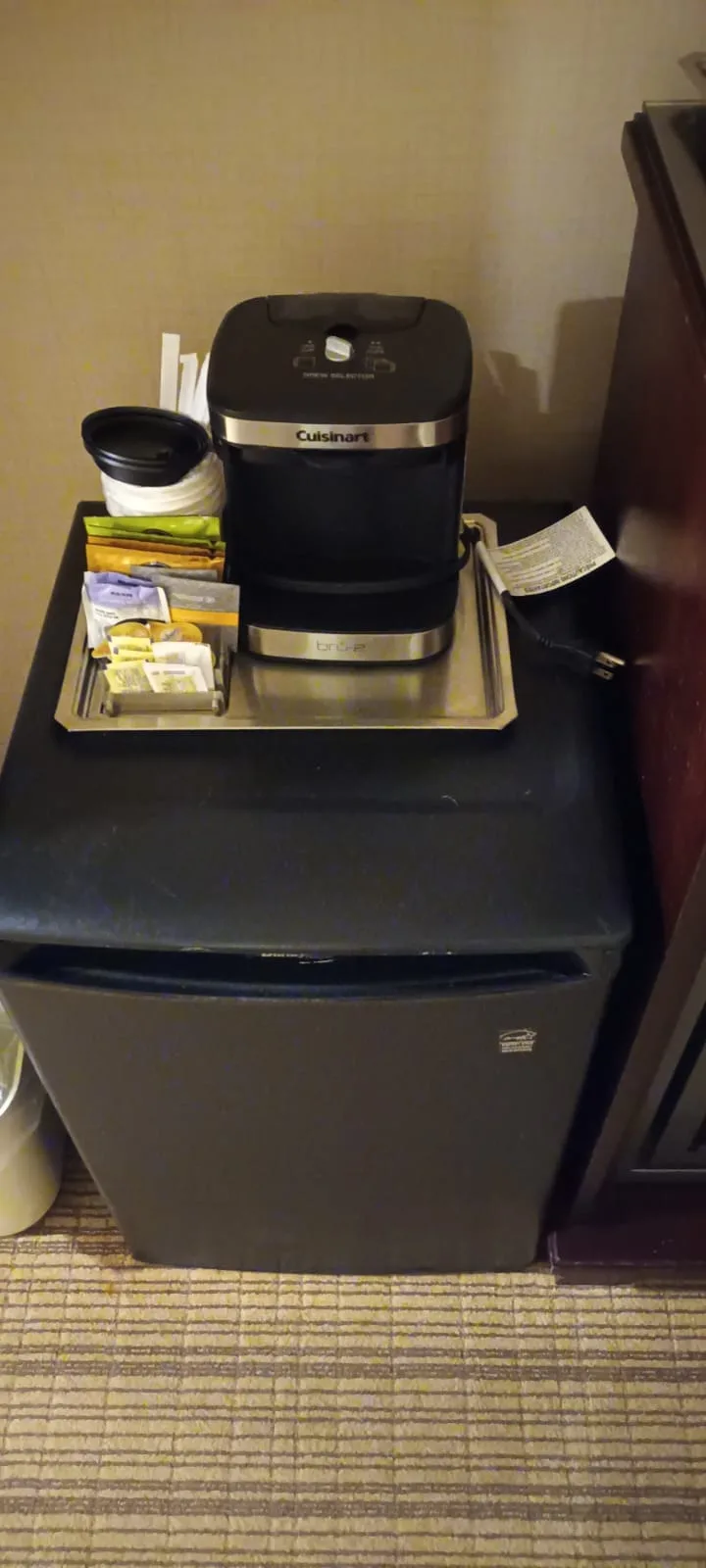 Kaffeemaschine auf Tablett neben Kühlschrank im Hotelzimmer