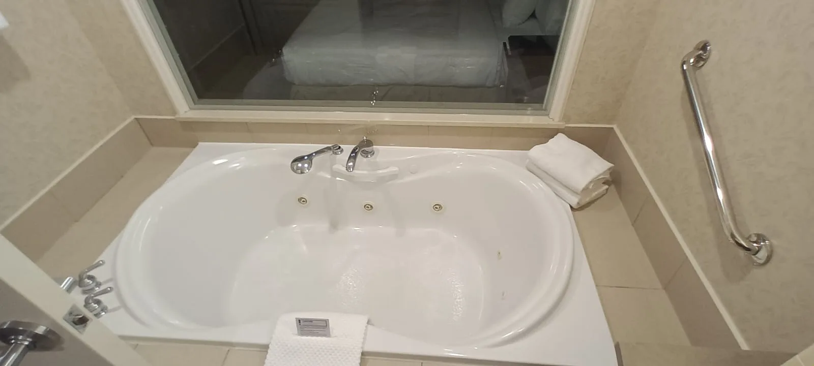 Hotelbad mit Whirlpool und Handtuch auf Rand