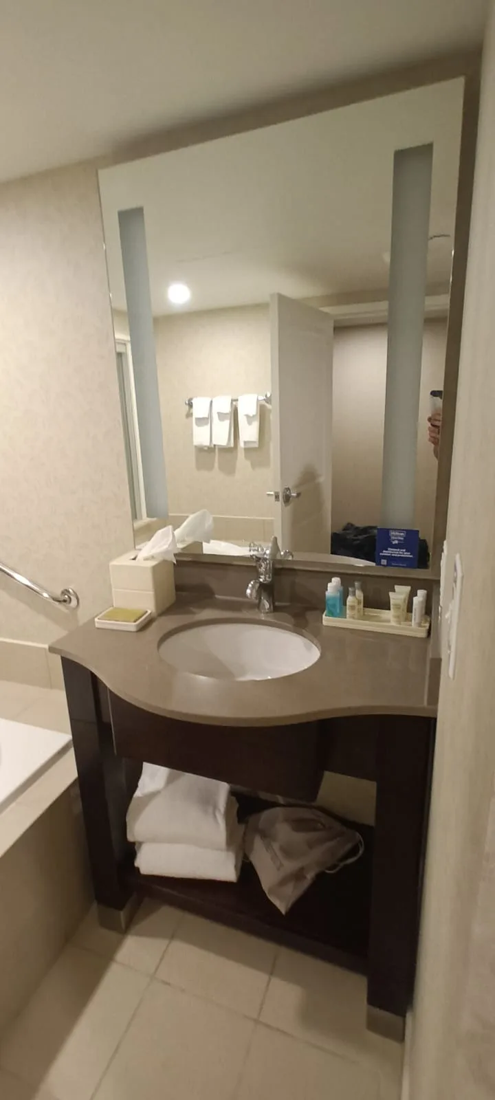 Hotelbadezimmer mit Waschbecken, Spiegel und Handtüchern