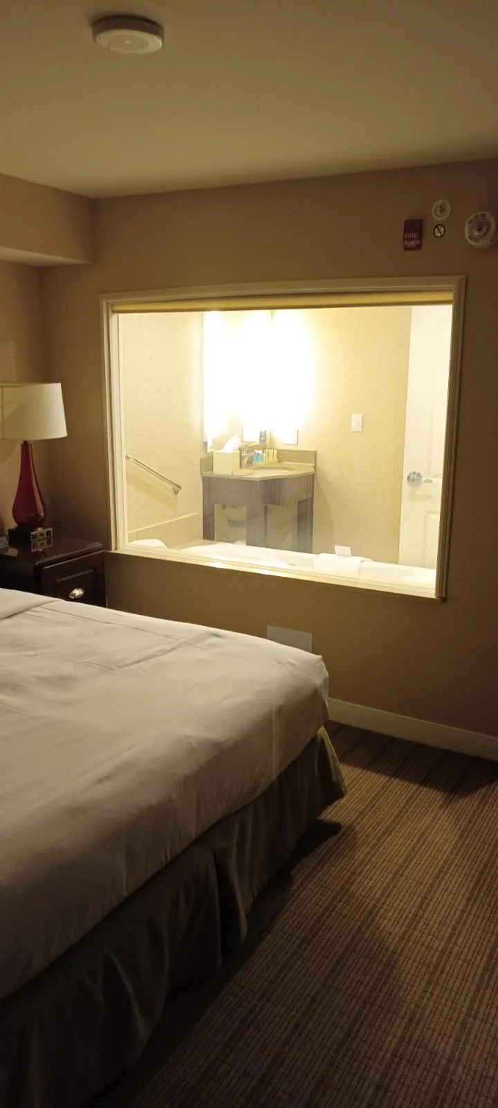Hotelzimmer mit Doppelbett und Spiegelsicht auf Badezimmer