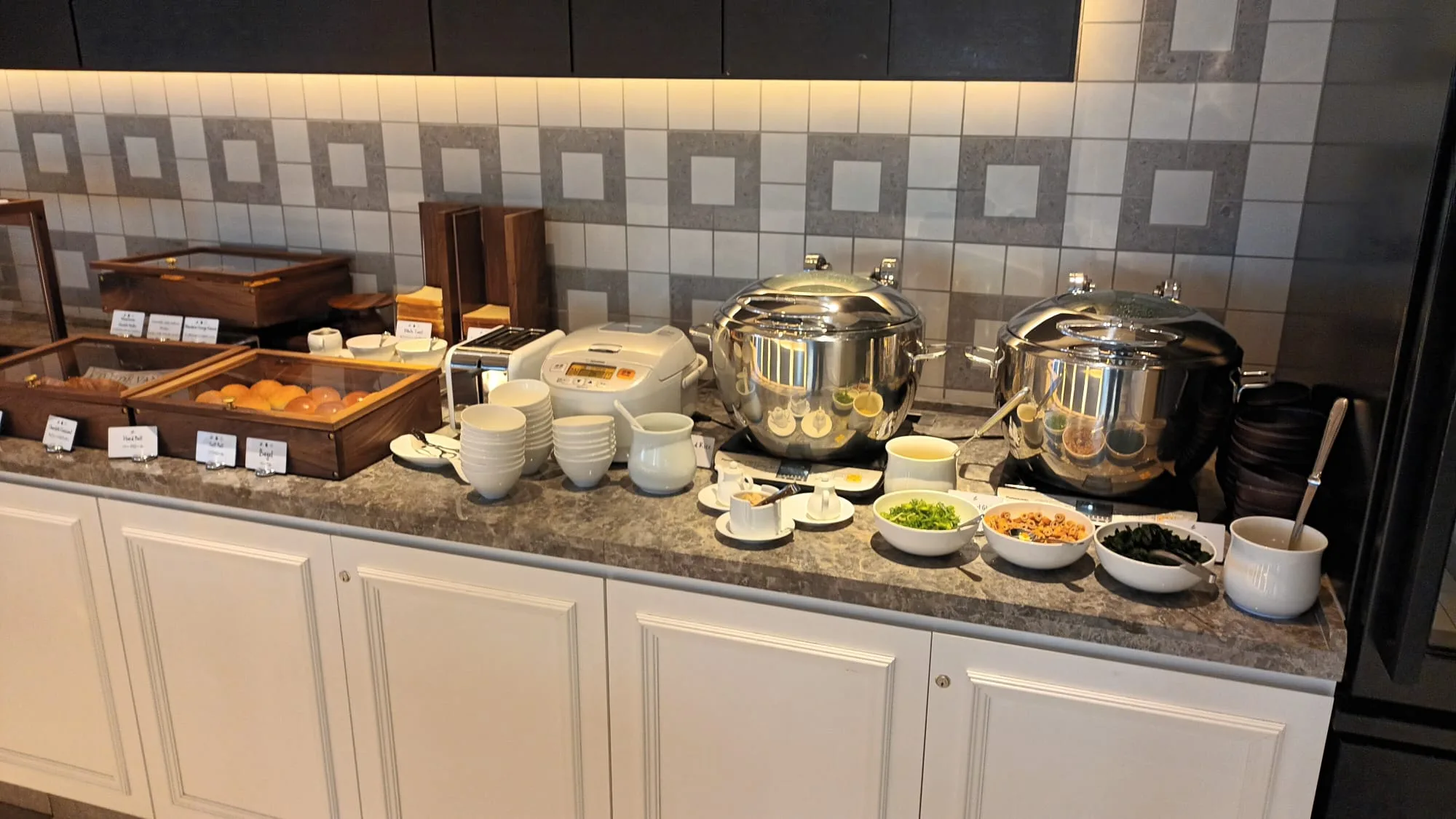 Frühstücksbuffet mit verschiedenen Gerichten und Geschirr auf dem Tisch