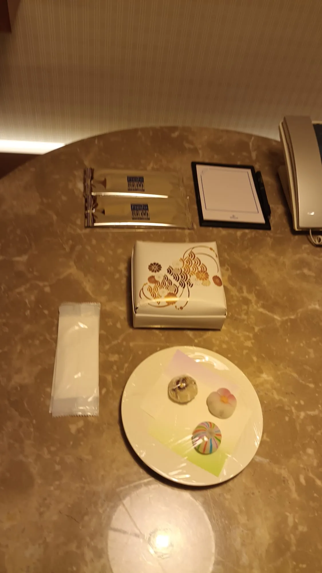 Hotelzimmereinrichtung mit Tee-Set und Süßigkeiten auf Teller