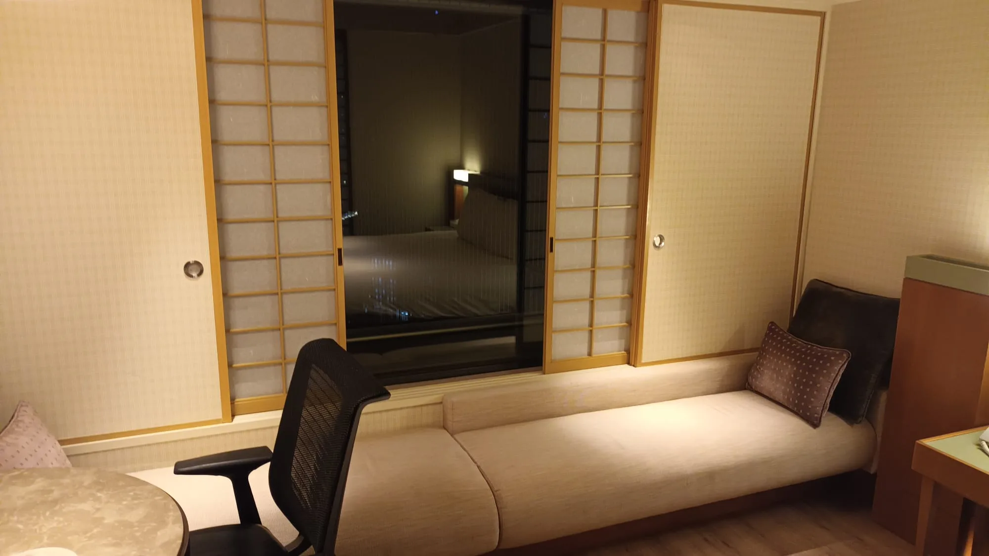 Hotelzimmer mit Schiebetüren und Couch im Vordergrund