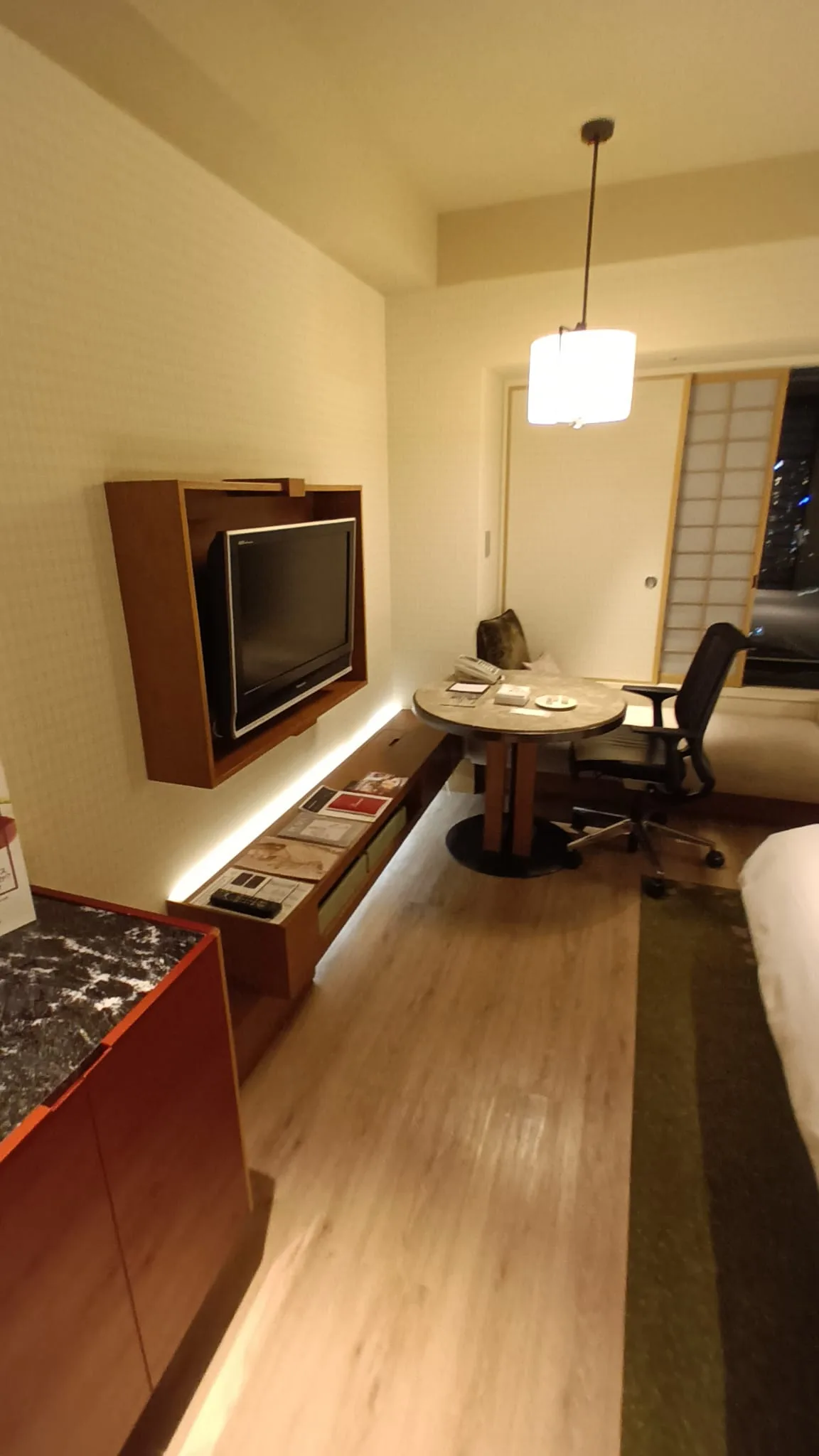 Hotelzimmer mit Schreibtisch, Stuhl und Fernseher