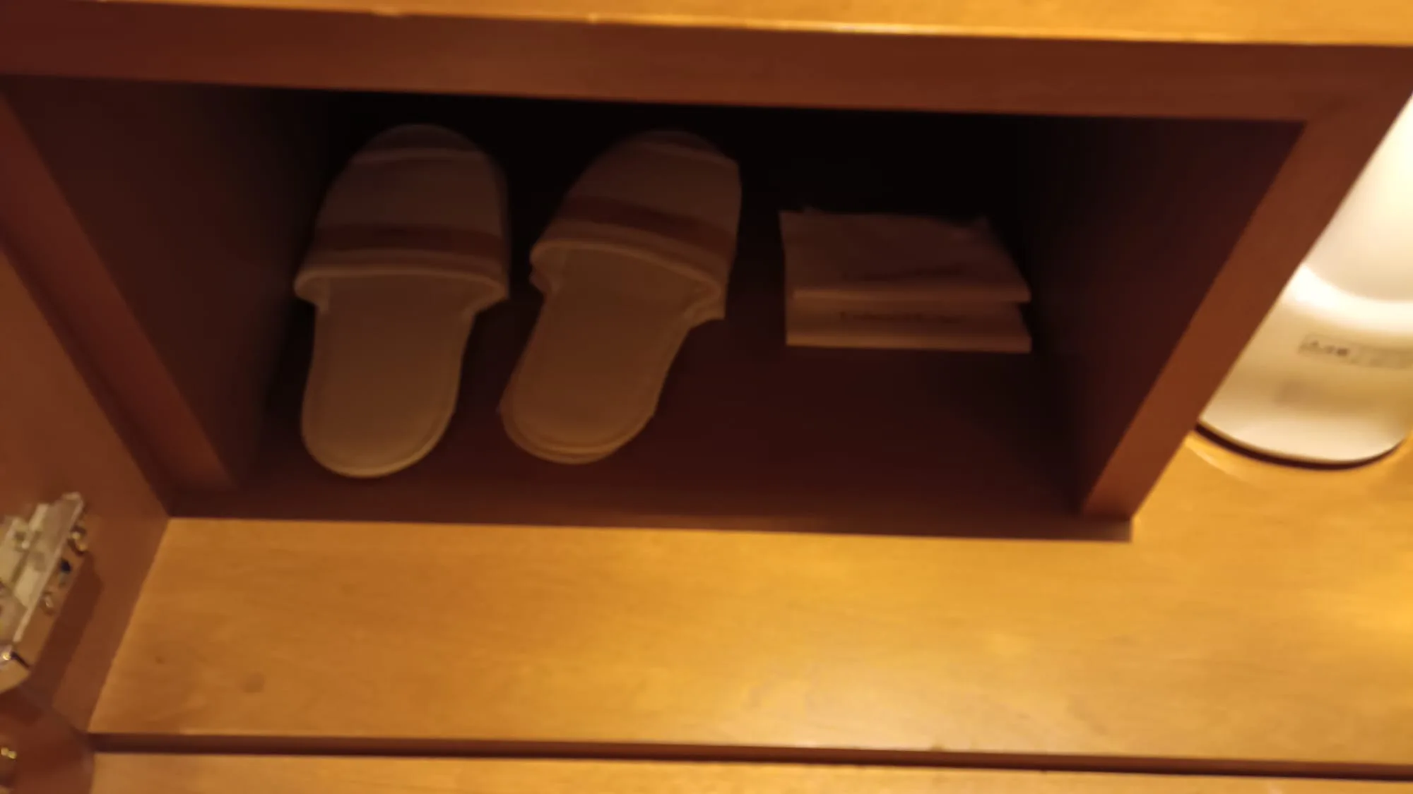 Hotelzimmerschuhhalter mit Slippern und Handtüchern
