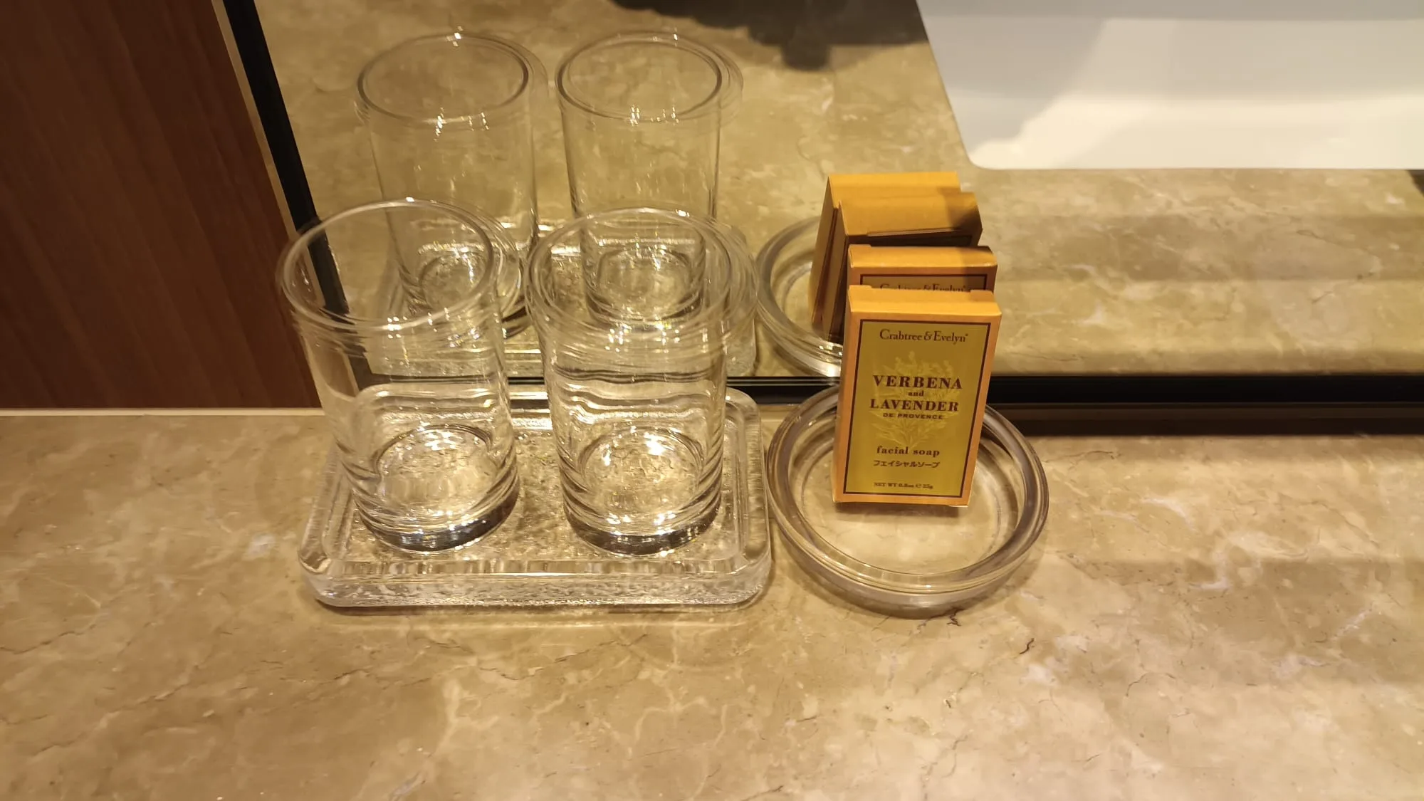 Hotelzimmerecke mit Gläsern auf Tablett und Duftöl