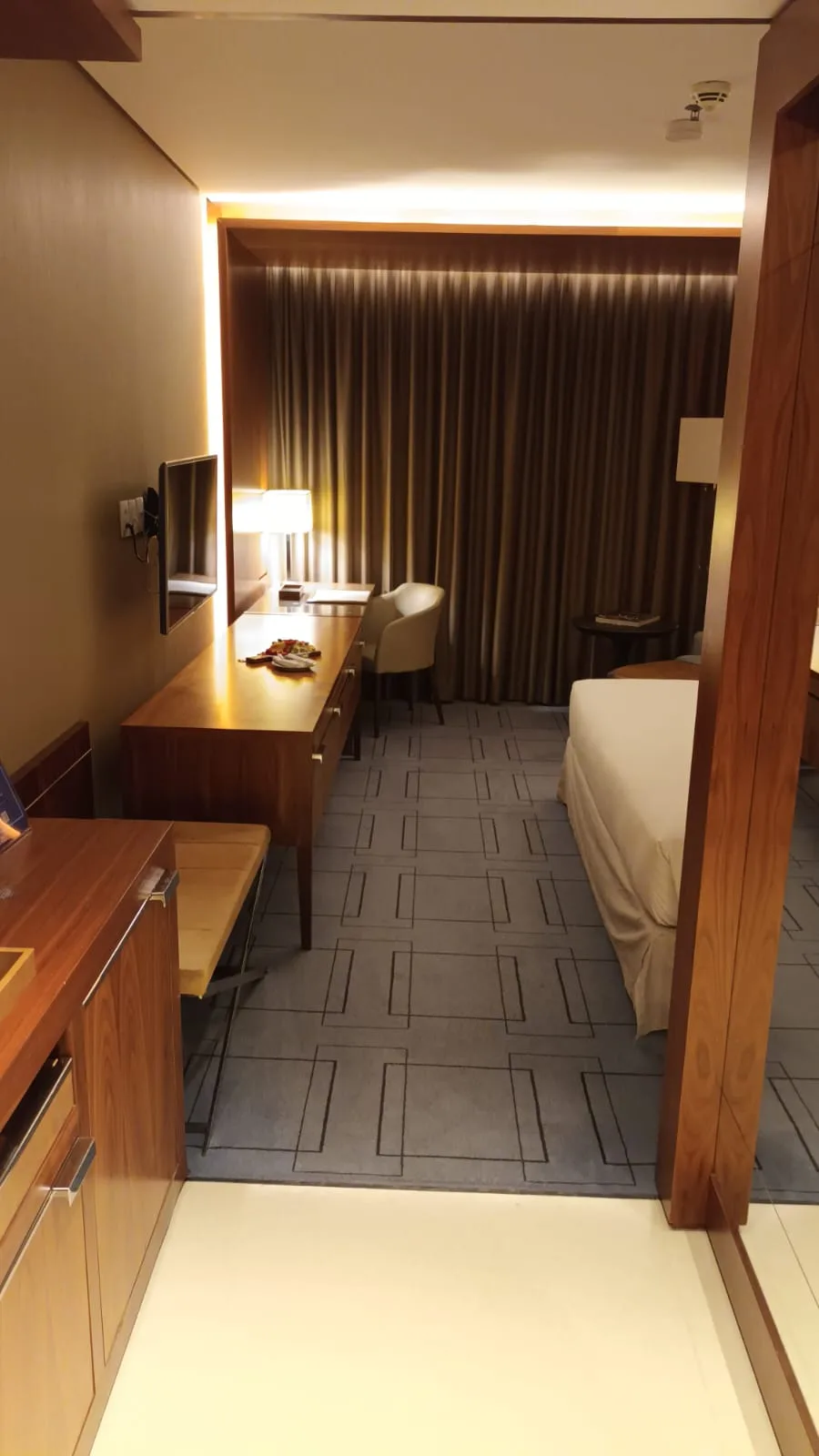 Hotelzimmer mit Doppelbett und Schreibtisch in neutralen Farben