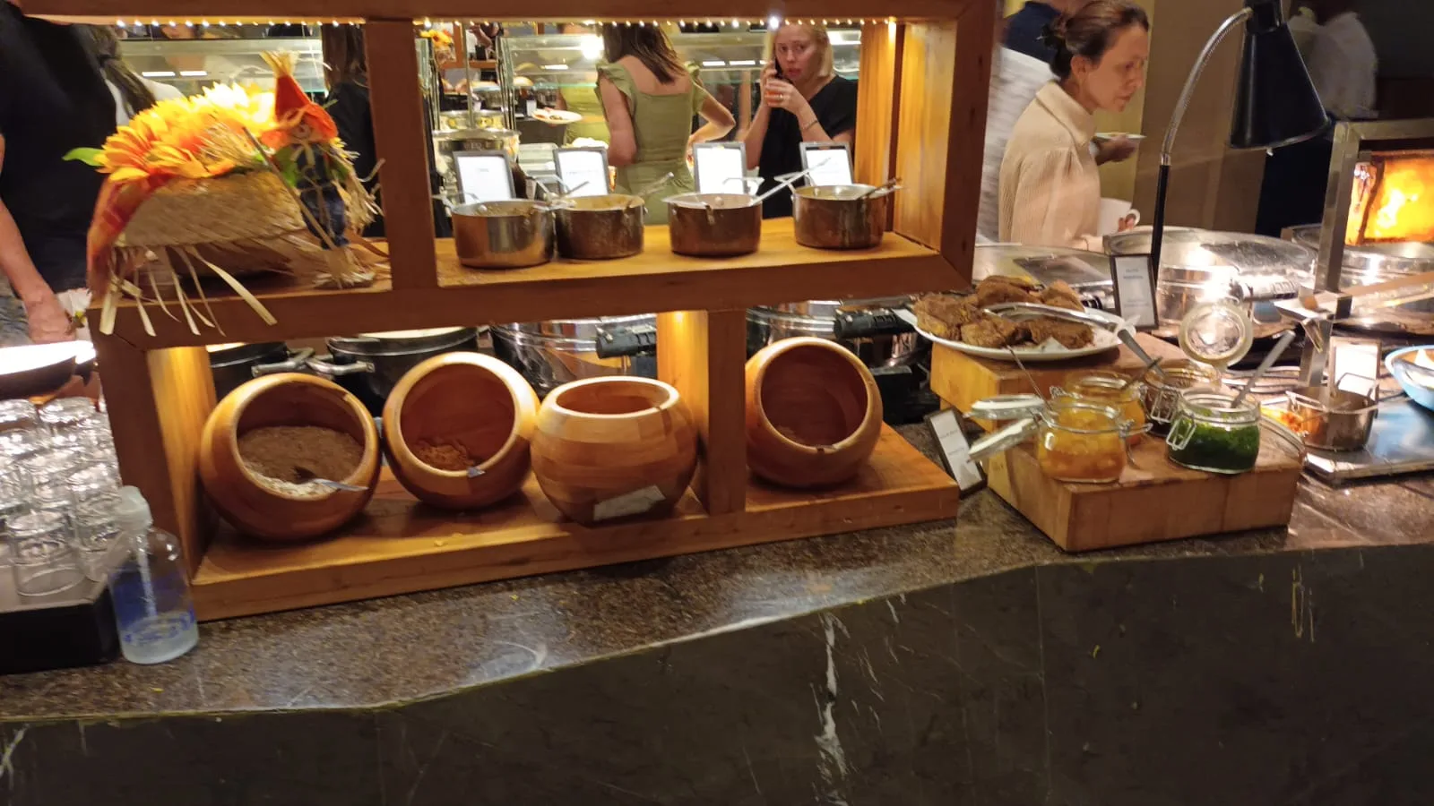 Buffet mit Holzschalen und Metallschüsseln auf Regal