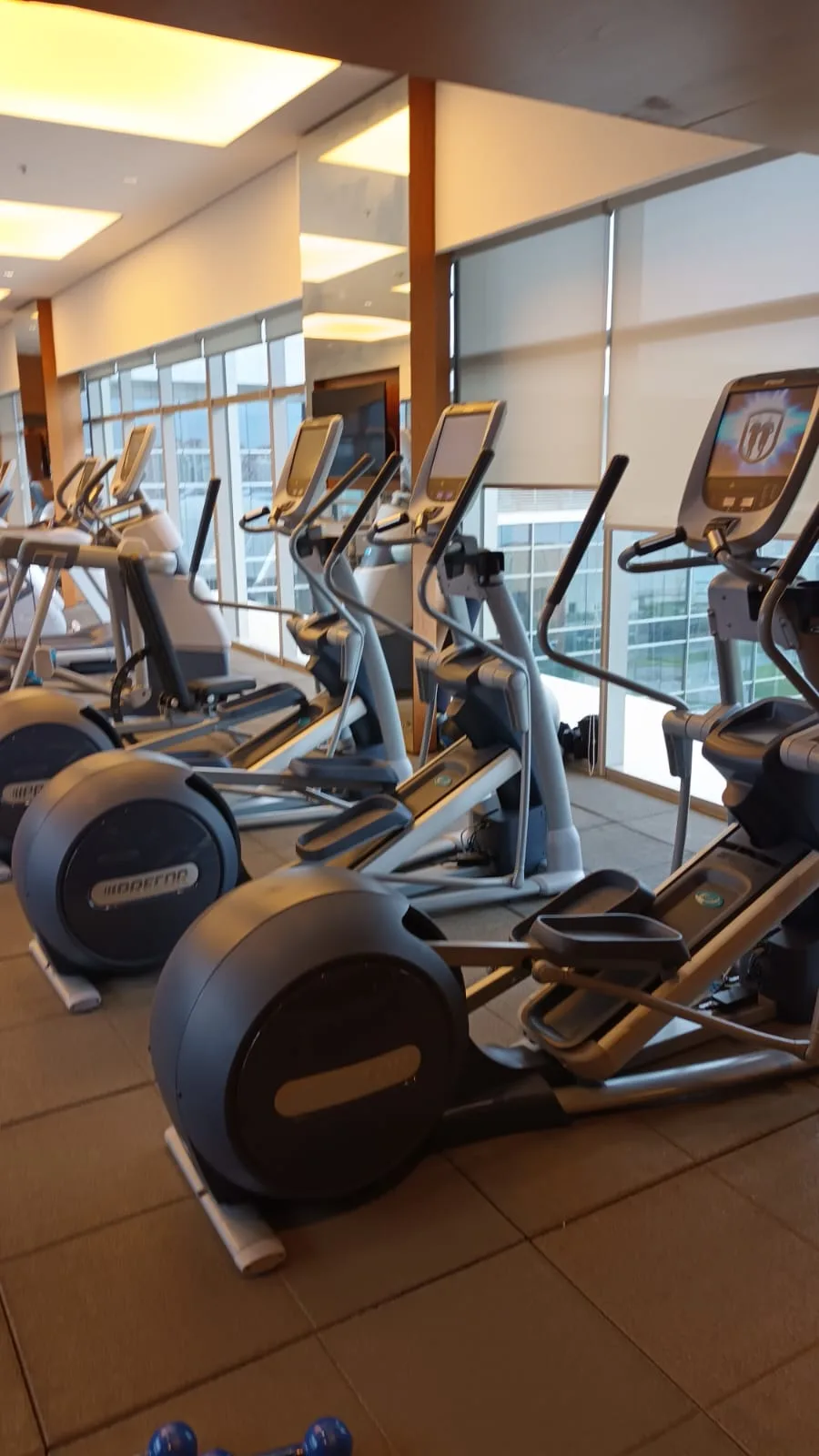 Fitnessgeräte in einem Fitnessstudio mit großen Fenstern