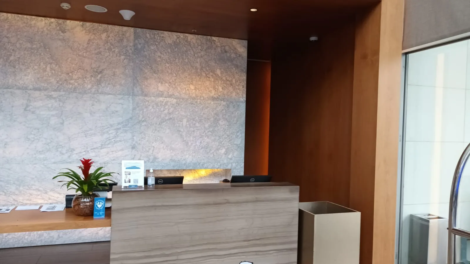 Rezeption eines Hotels mit Marmorwand und Holztisch