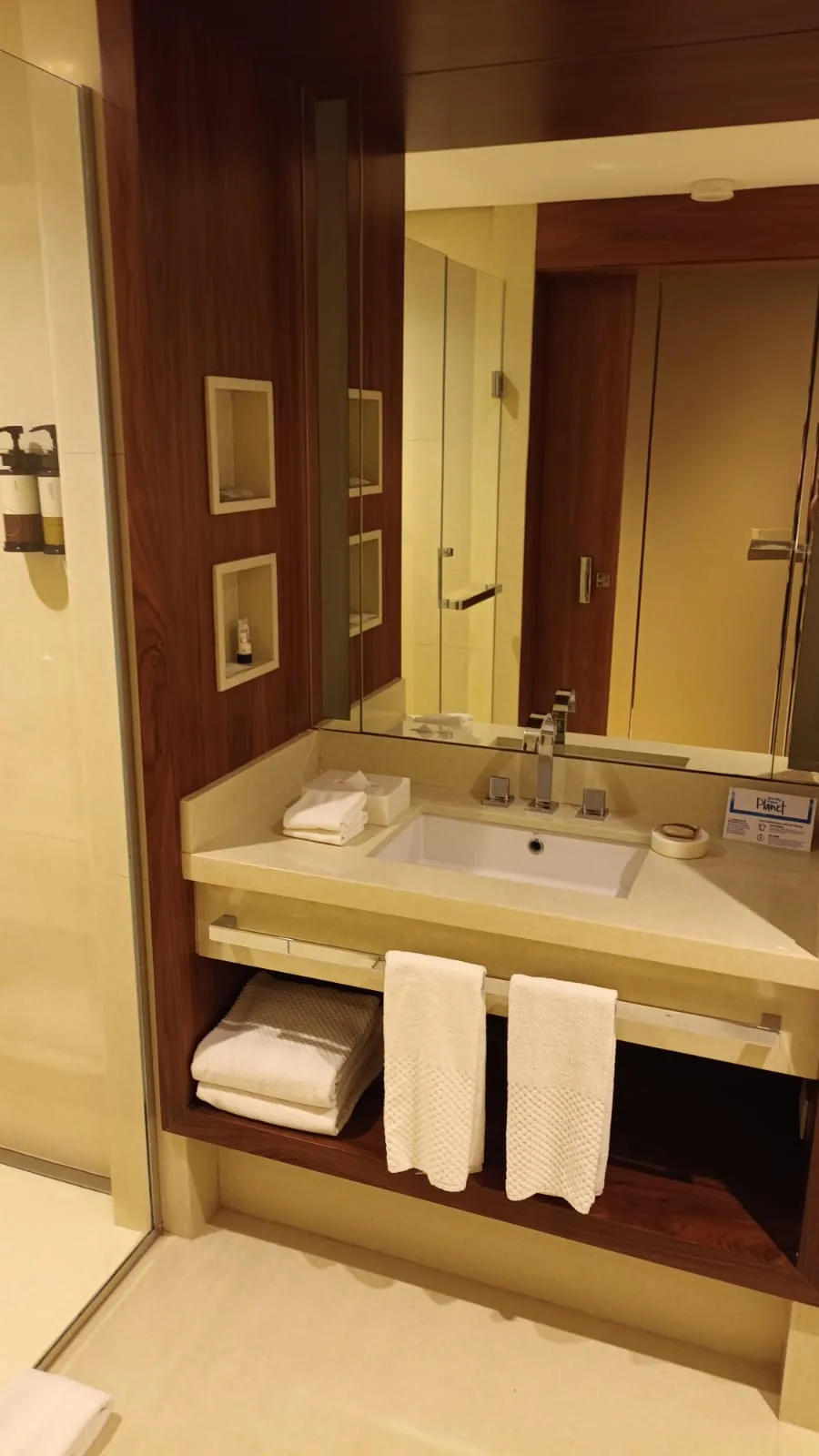 Hotelbadezimmer mit Waschbecken, Spiegel und Handtüchern