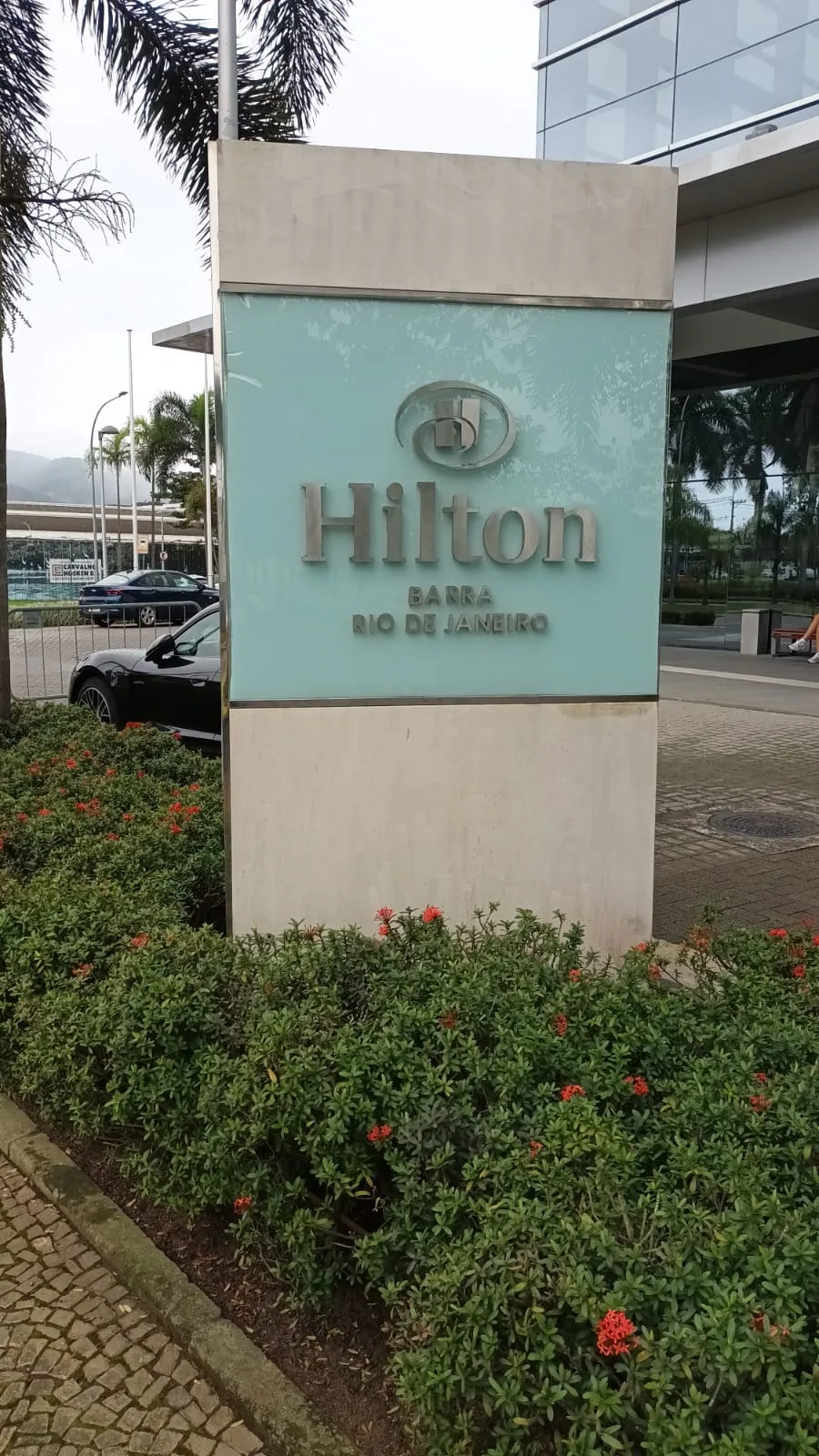 Hilton-Schild mit Logo und Adresse am Straßenrand