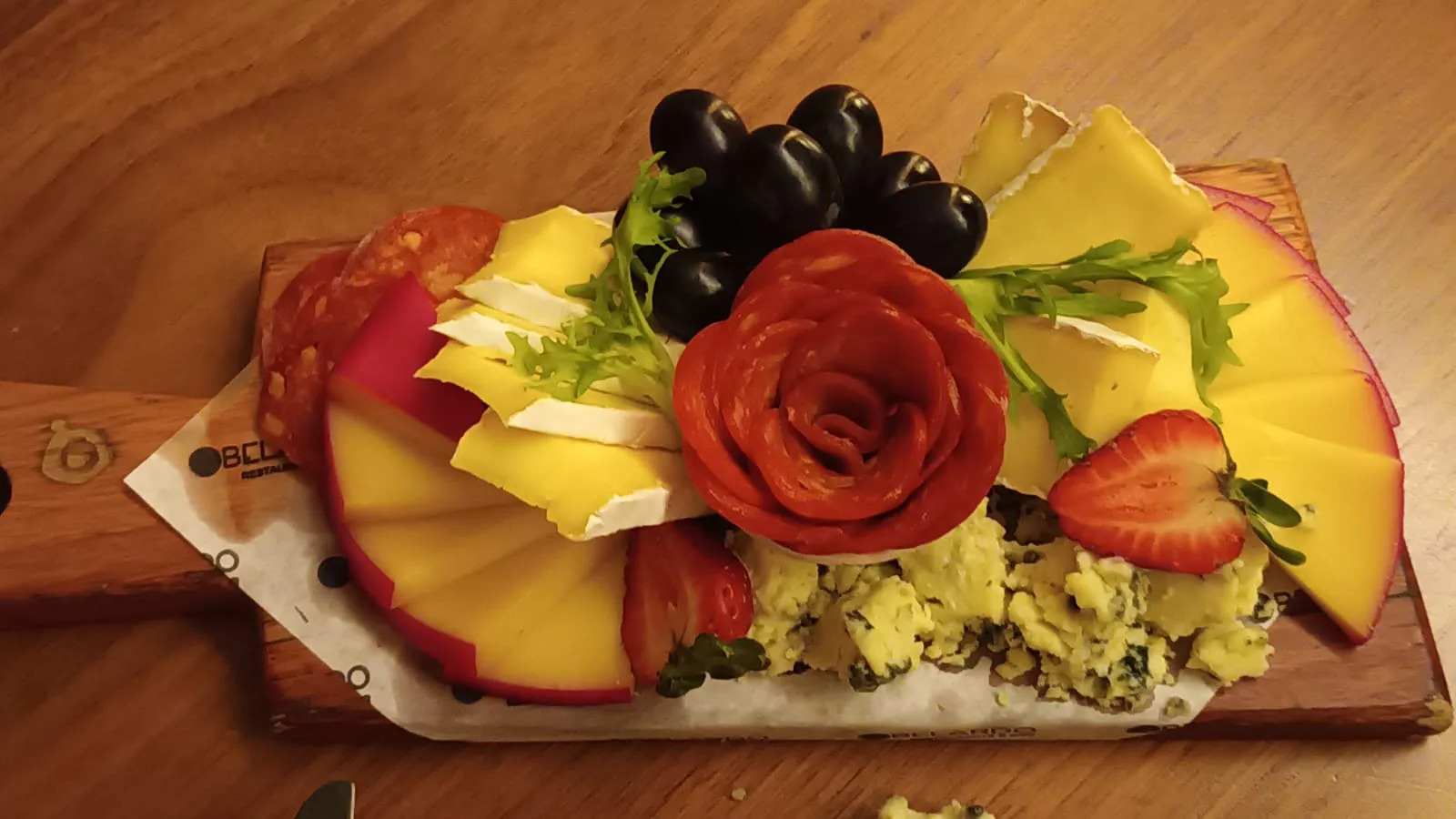 Käseplatte mit Tomaten, Erdbeeren und Trauben