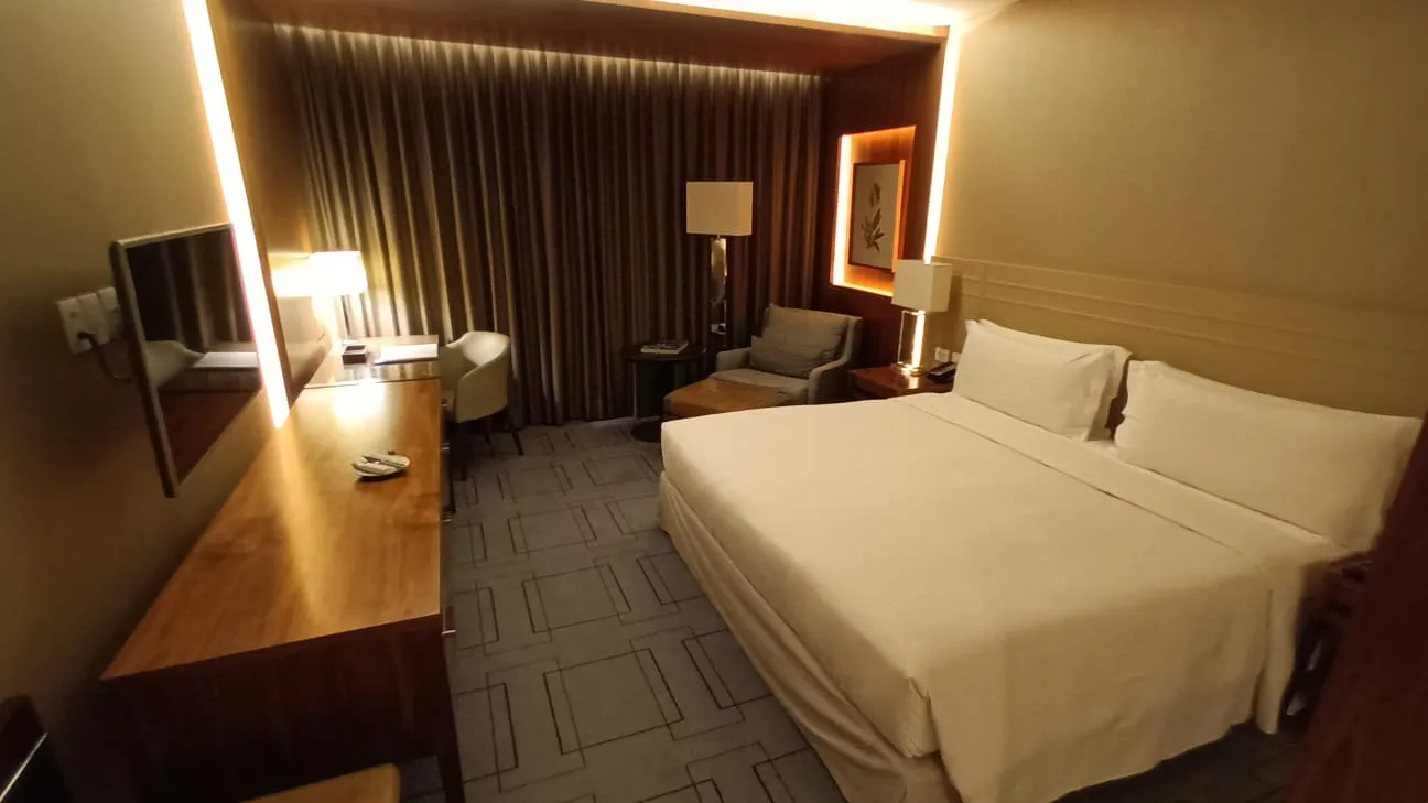 Hotelzimmer mit Doppelbett und Tagesdecke in Grautönen
