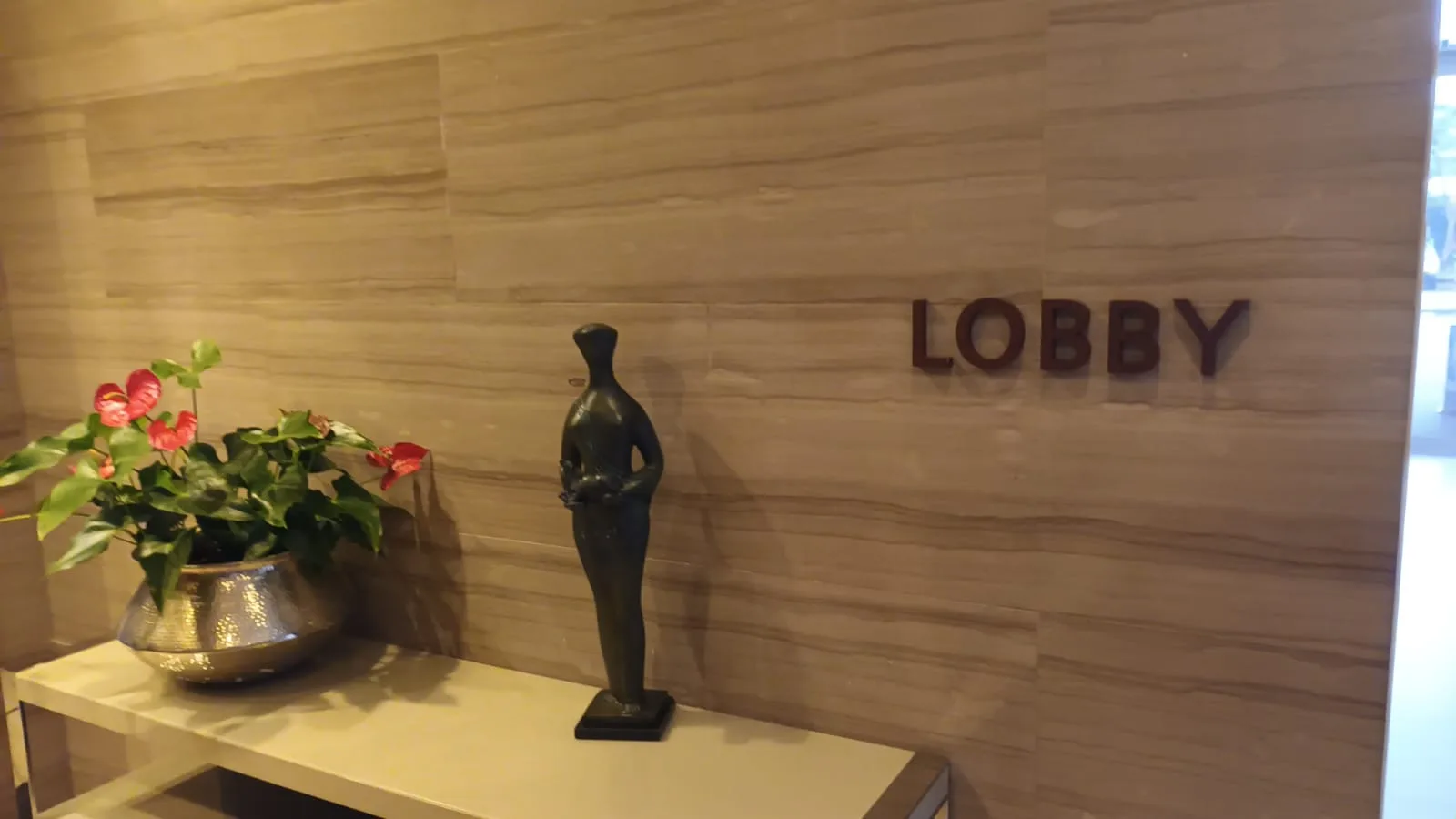Lobby-Eingang mit Skulptur und Blumen