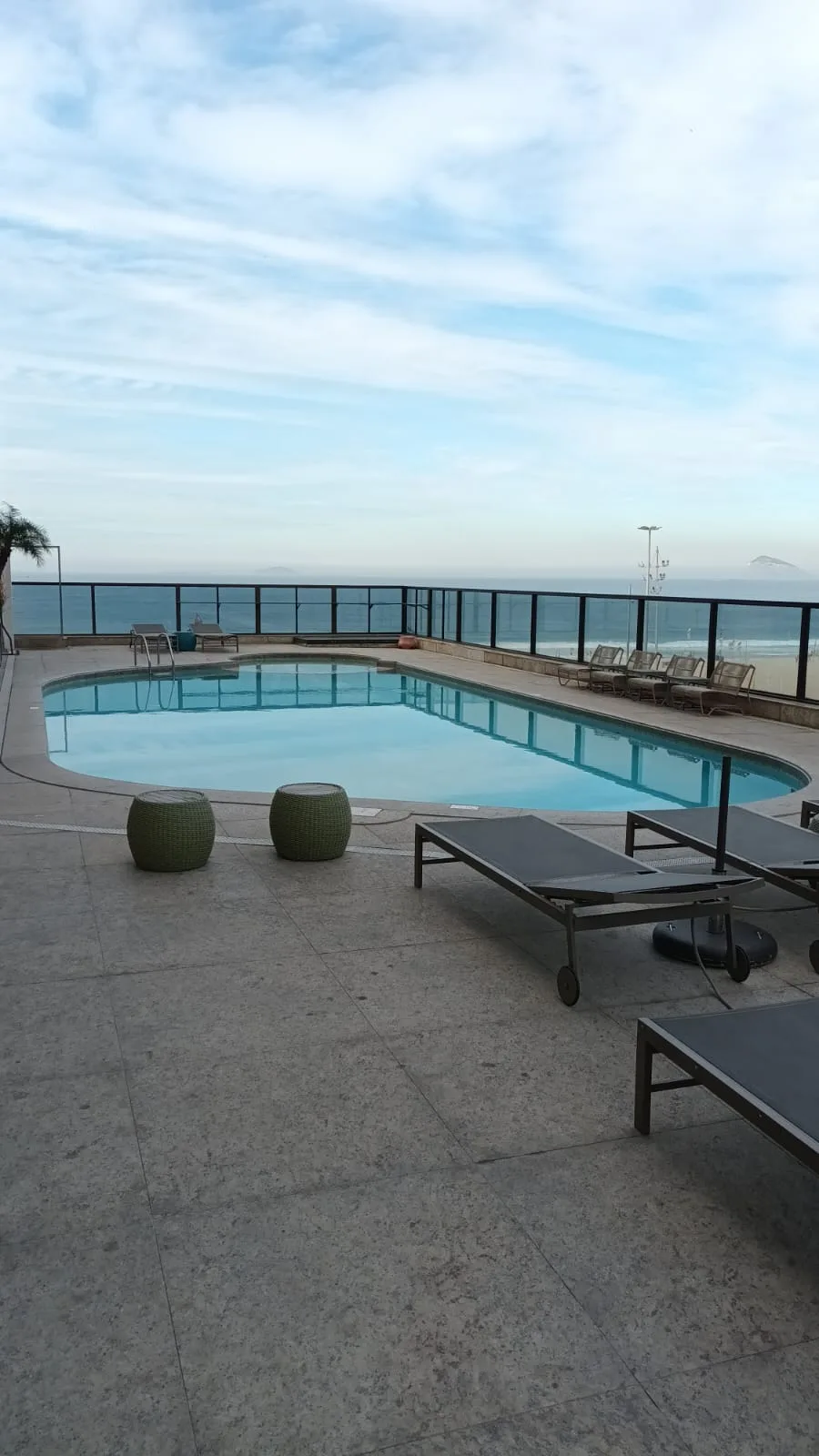 Hotelpool mit Liegestühlen und Meerblick