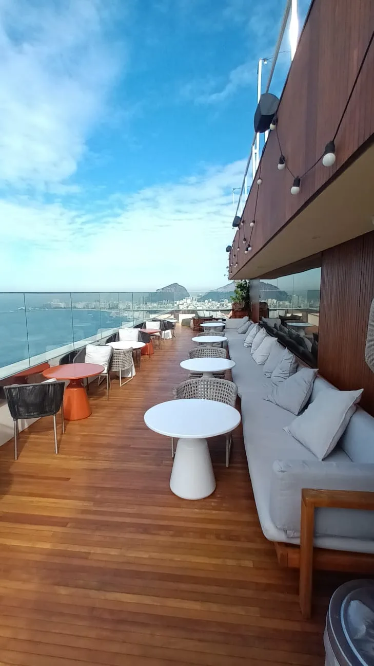 Terrasse mit Holzboden, Sitzmöbeln und Blick auf Stadt und Meer