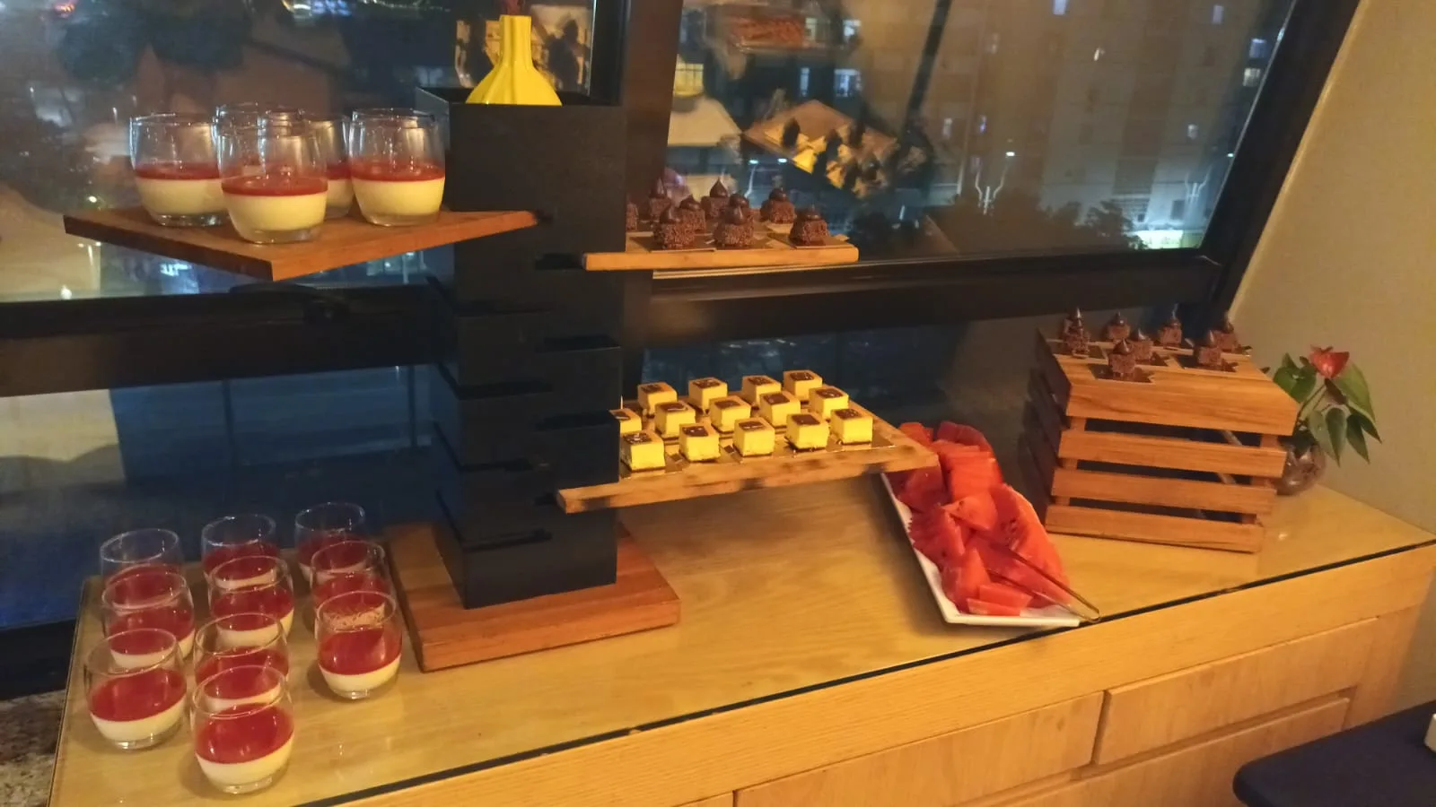 Buffet mit verschiedenen Desserts und Früchten auf Holzregalen