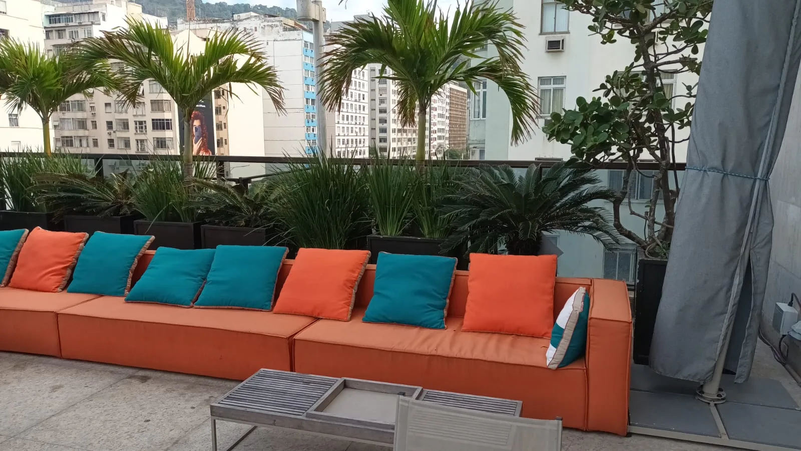 Terrasse mit orangefarbenen Sofas und blauen Kissen
