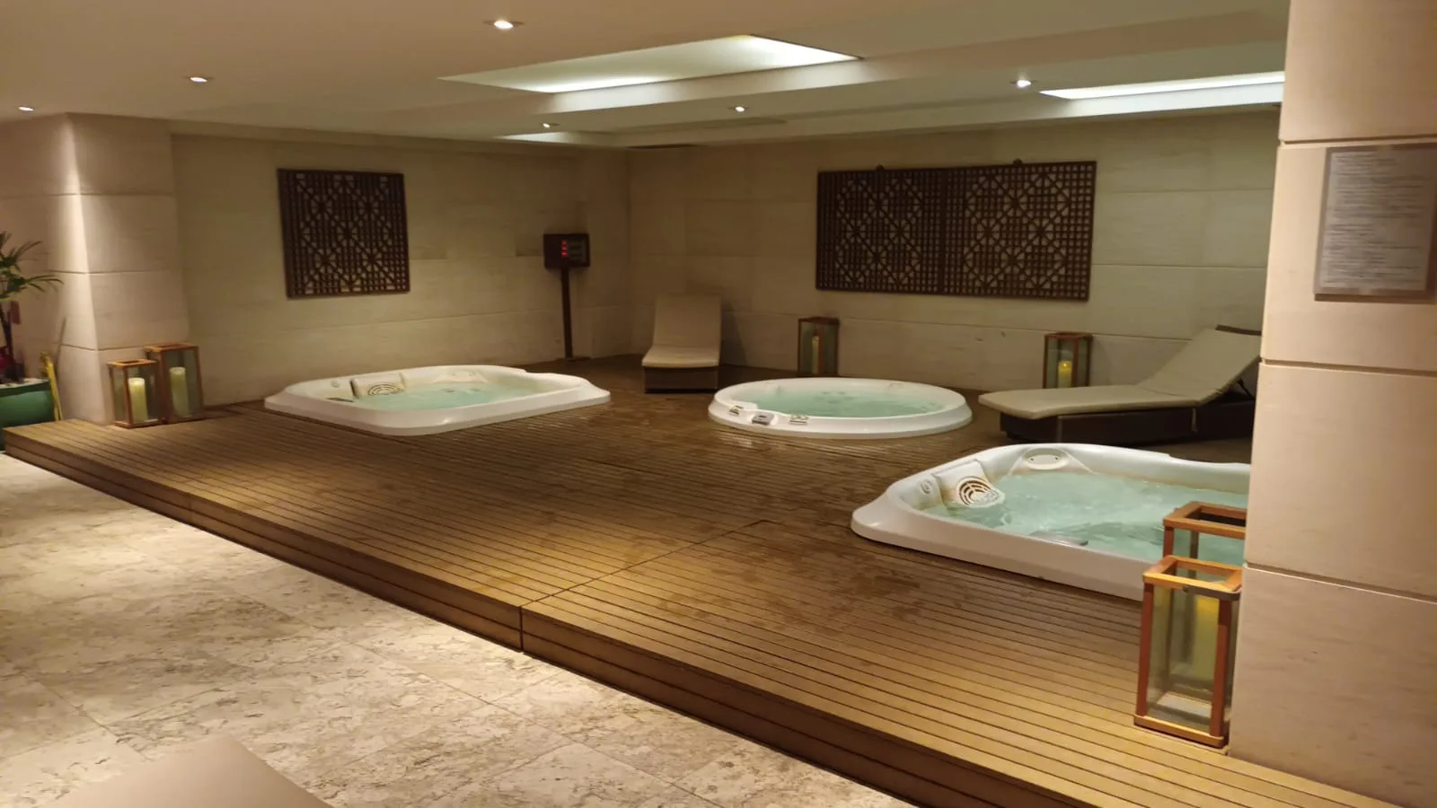 Drei Whirlpools in einem Wellnessbereich mit Holzboden und Wandverkleidung