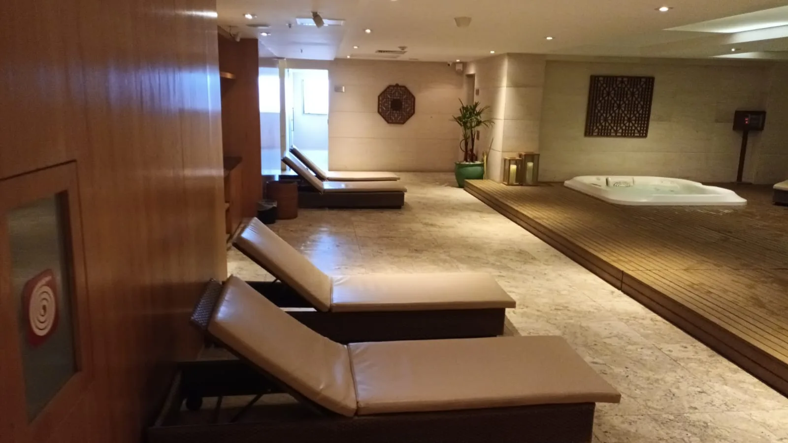 Entspannungsbereich mit Liegestühlen und Whirlpool im Hotel