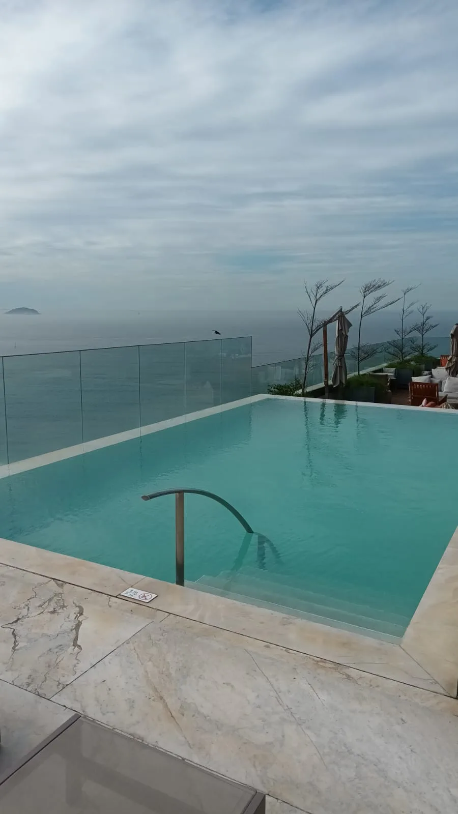 Infinity-Pool mit Blick aufs Meer und bewölktem Himmel