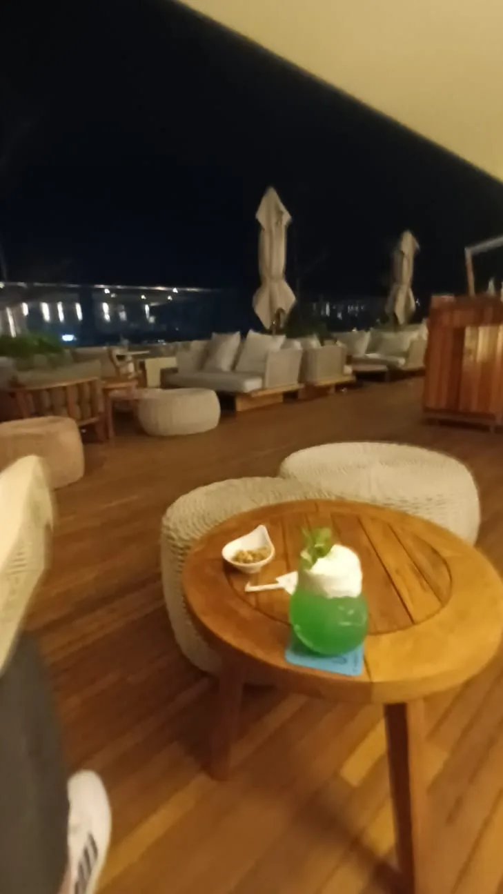 Außenbereich mit Holztischen bei Nacht