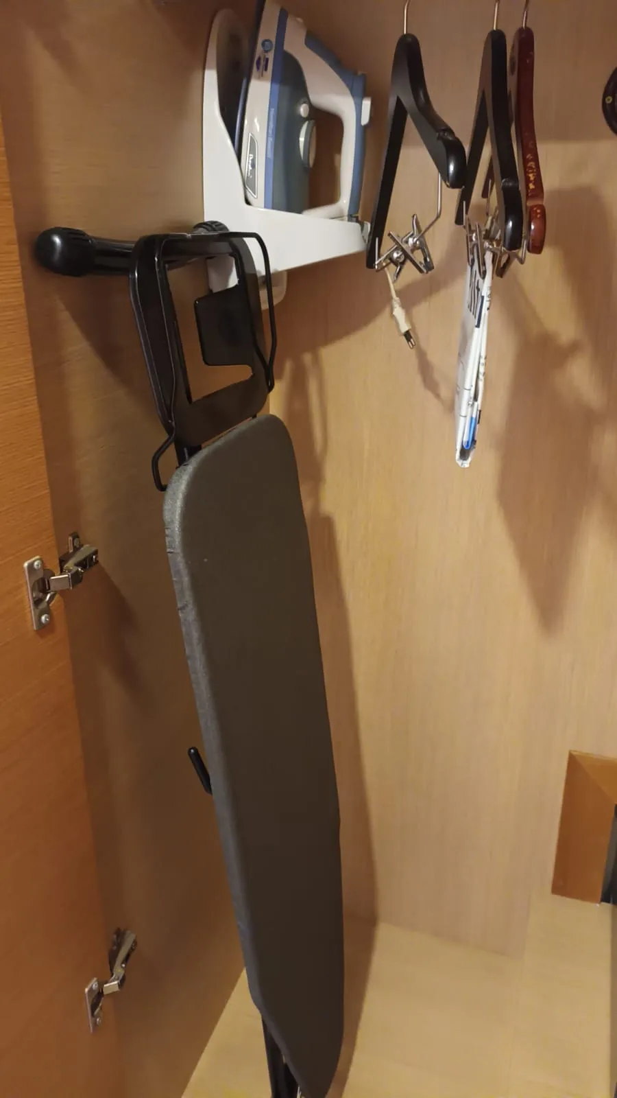Wandregal mit Bügeleisen und Kleiderbügeln
