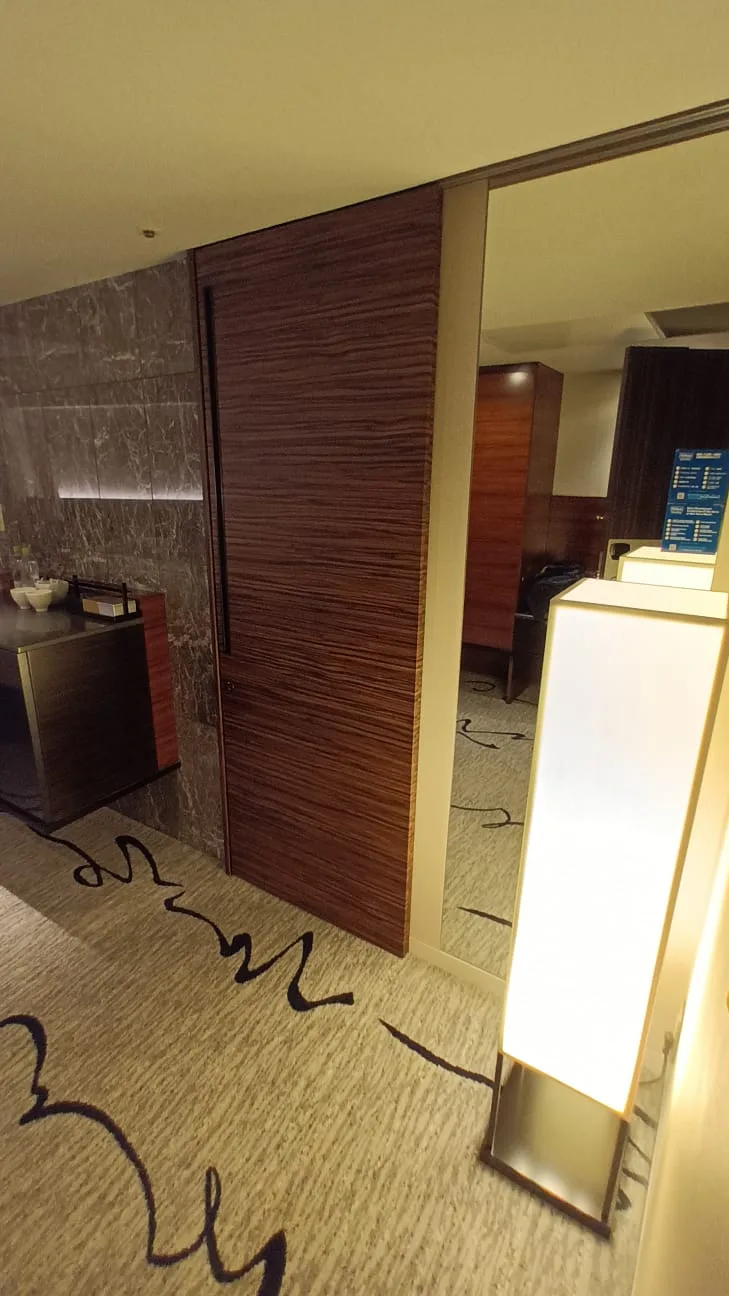 Hotelzimmer mit Holztür und moderner Beleuchtung