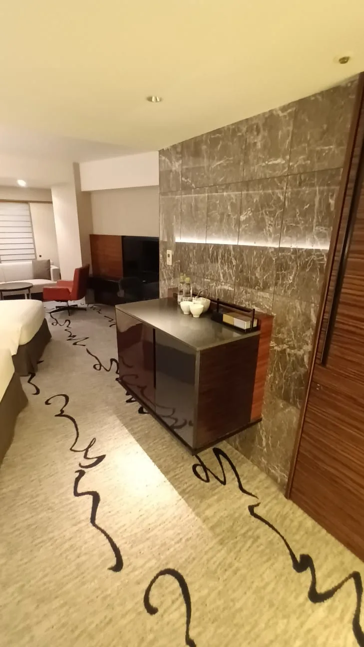 Hotelzimmer mit Doppelbett und Marmorwand