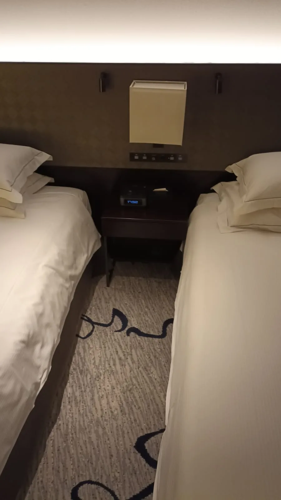 Hotelzimmer mit Doppelbetten und Nachttisch