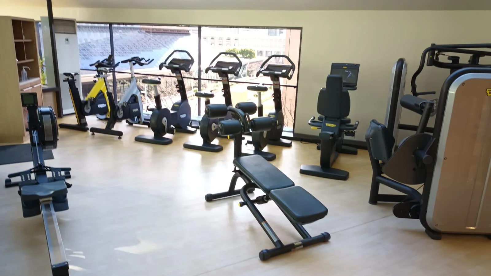Fitnessraum mit verschiedenen Trainingsgeräten und Fensterblick