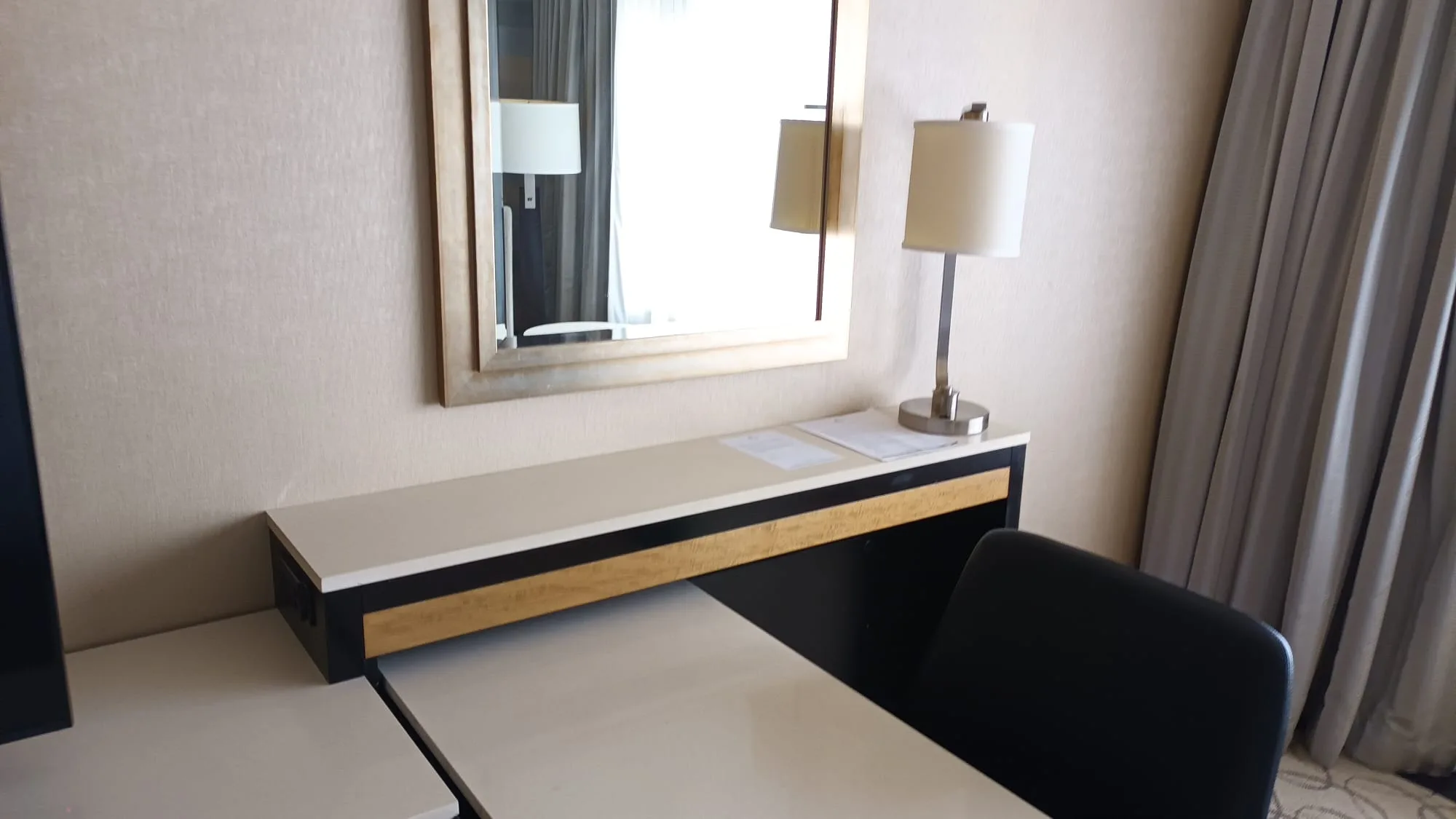 Hotelzimmer mit Schreibtisch und Spiegel