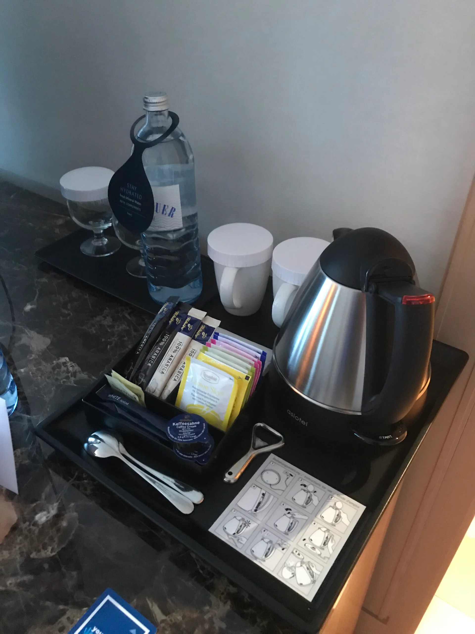 Hotelzimmereinrichtung mit Wasserkocher, Teebeuteln und Getränkeflasche
